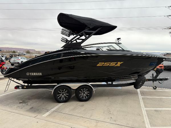 2025 Yamaha Boats 255XD, sleek black design on a trailer, side view.