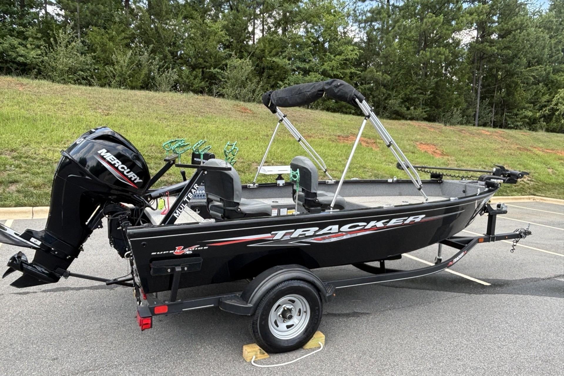 2022 Tracker Super Guide V-16 T boat with Mercury engine on trailer, parked outdoors.