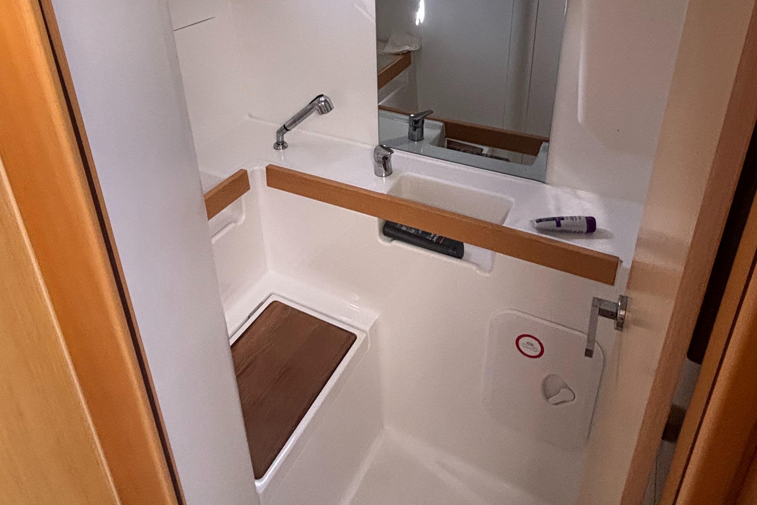 Compact bathroom in a 2015 Beneteau Oceanis 35 sailboat, featuring a sink and mirror.