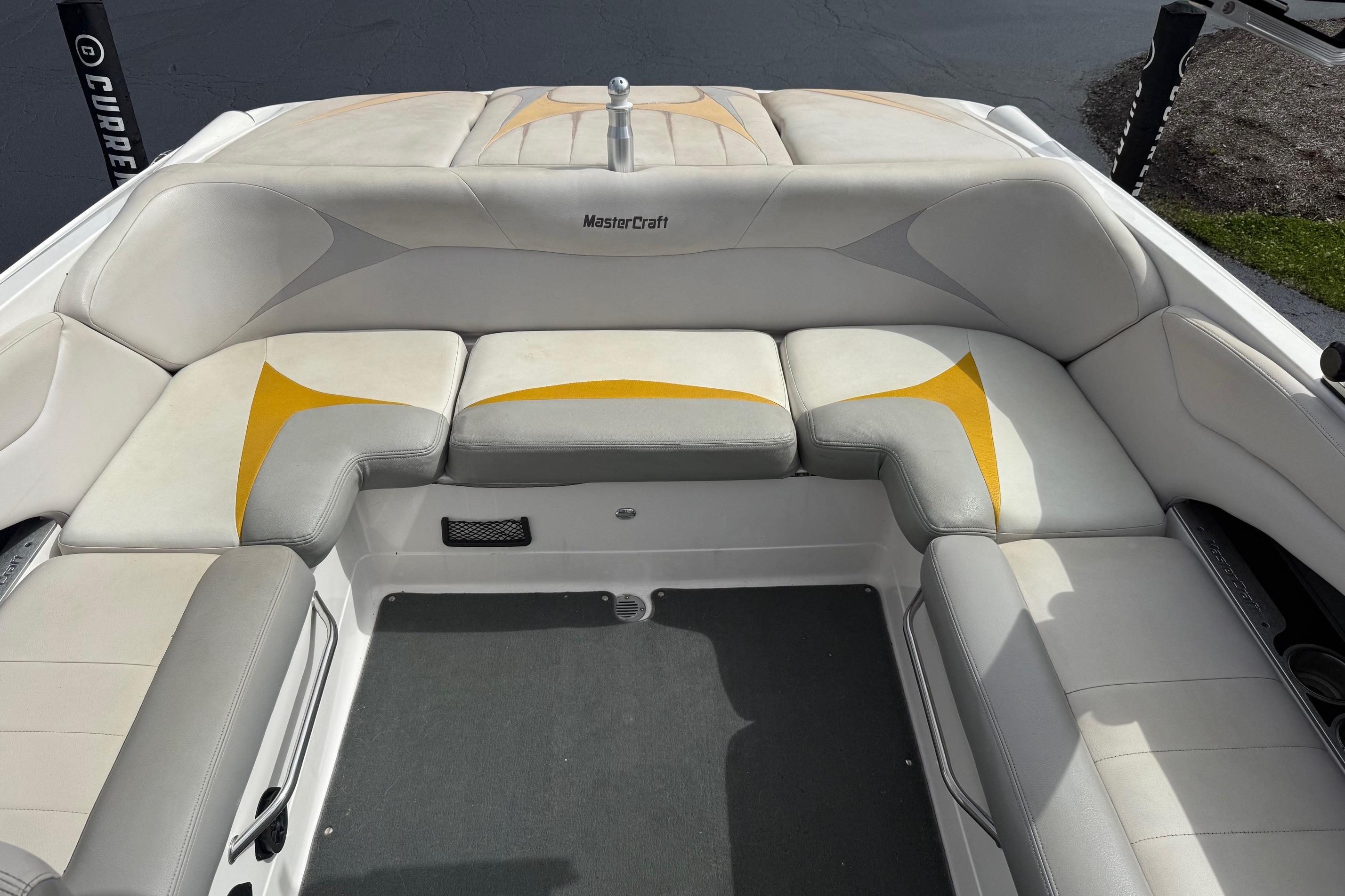 2008 MasterCraft X-15 boat interior with white and yellow cushioned seating.
