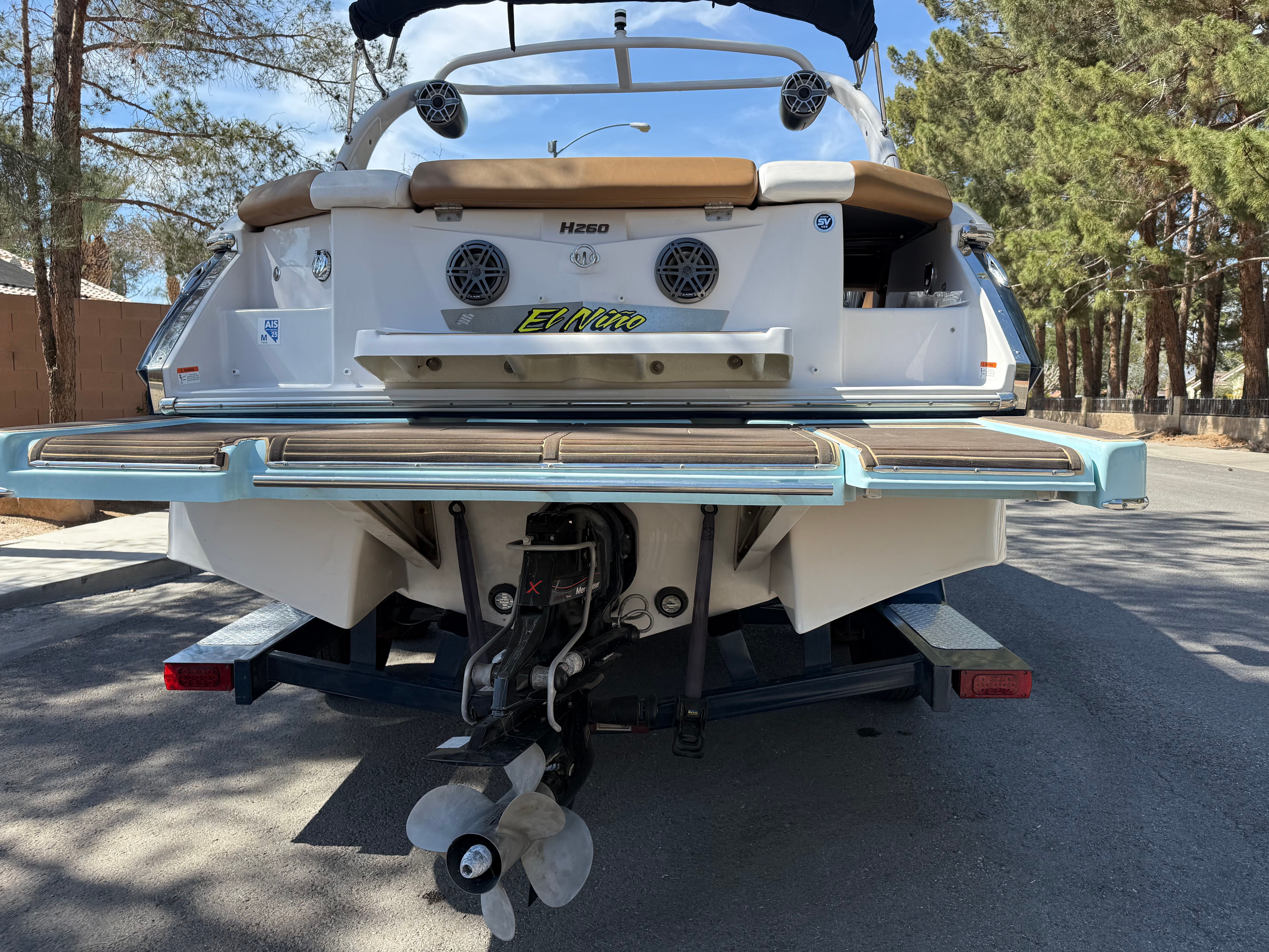 Rear view of a 2019 Four Winns H260 boat on a trailer.