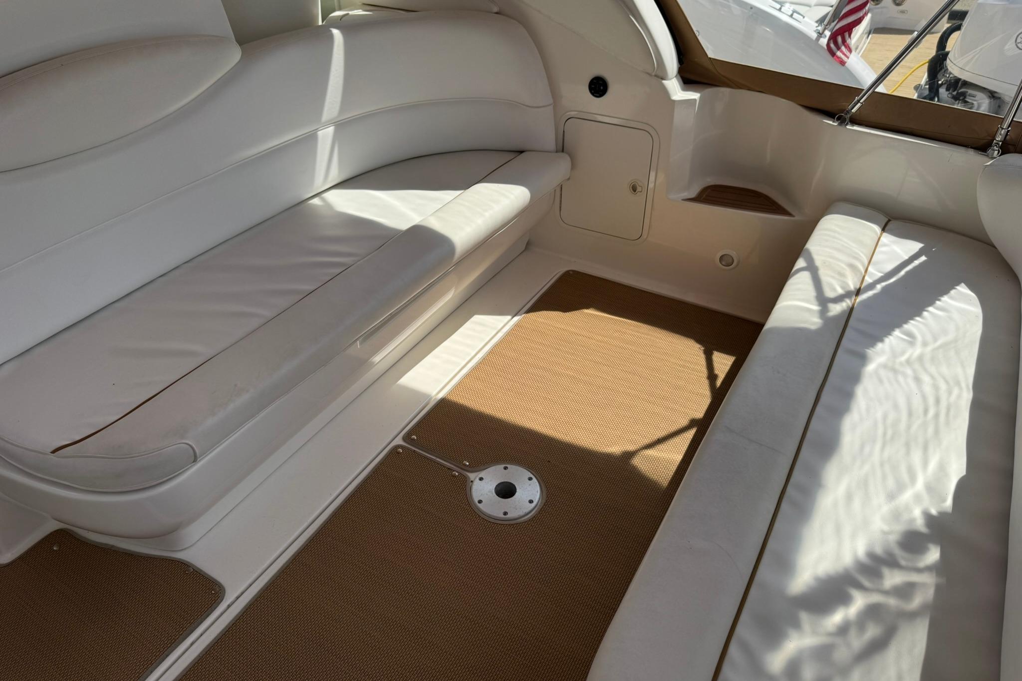Interior seating area of a 2001 Sea Ray 340 Sundancer yacht with white upholstery.