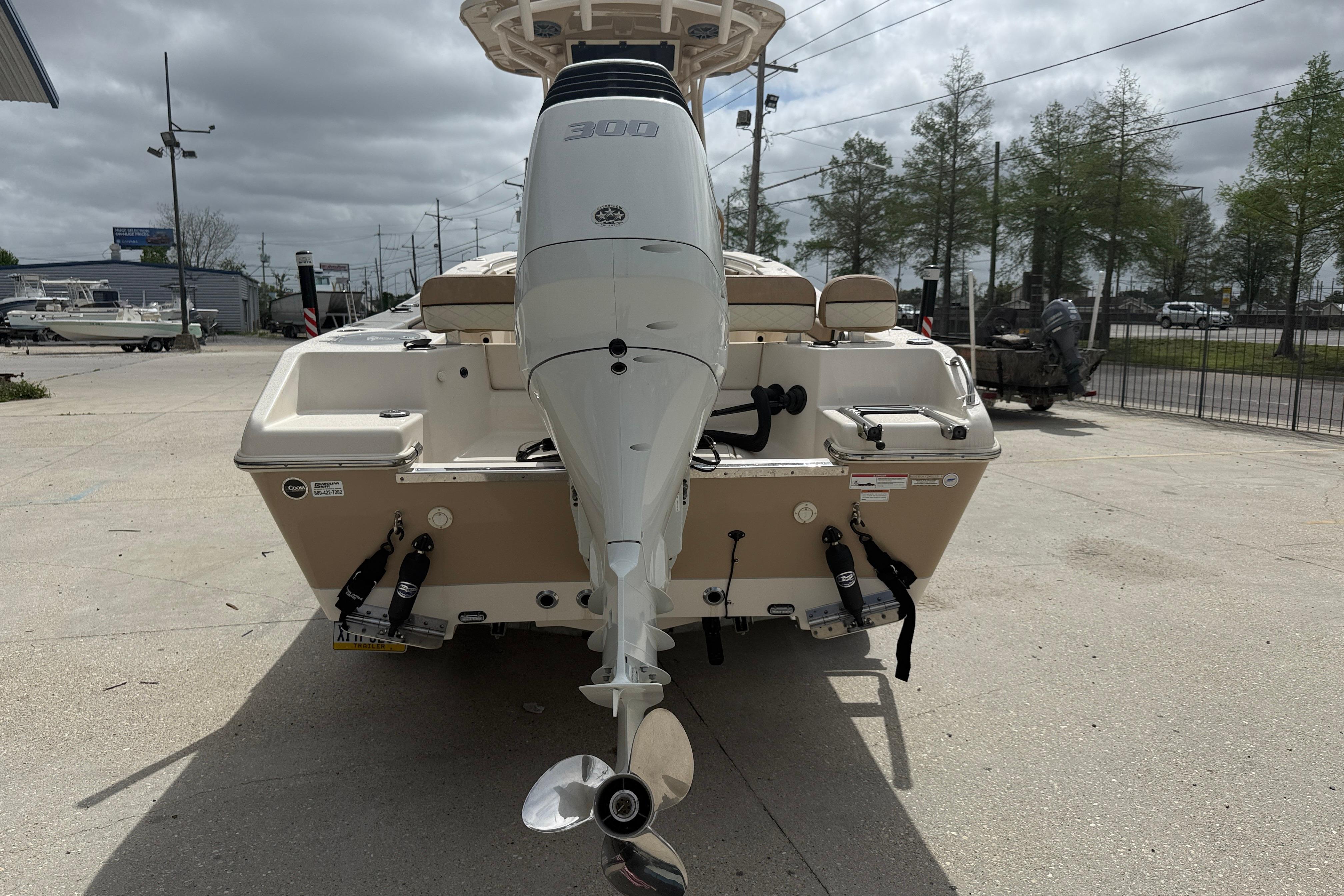 2023 SeaChaser 24 HFC boat with powerful outboard motor, parked on concrete surface.