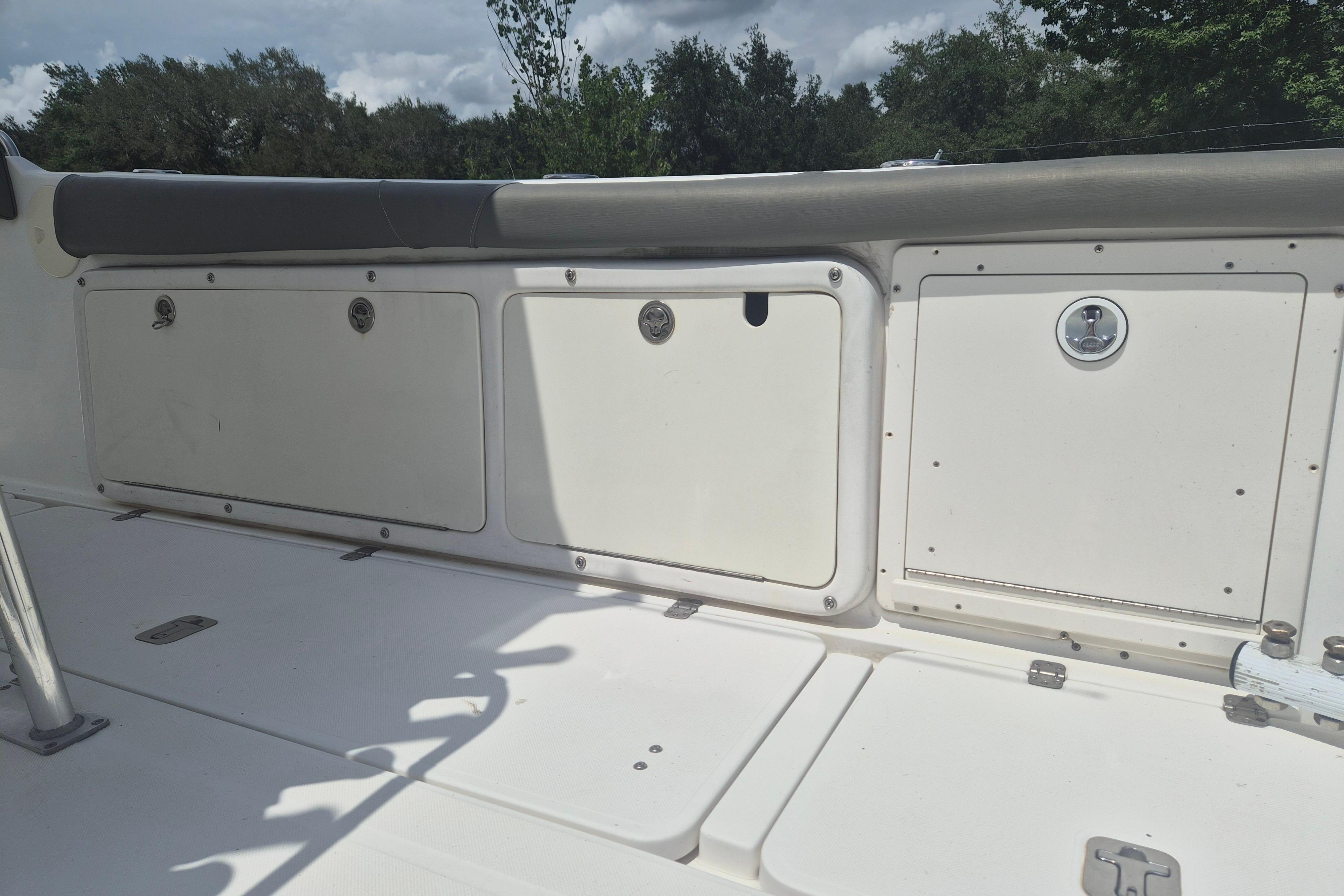 2006 Century 2900 Center Console boat storage compartments under cloudy sky.