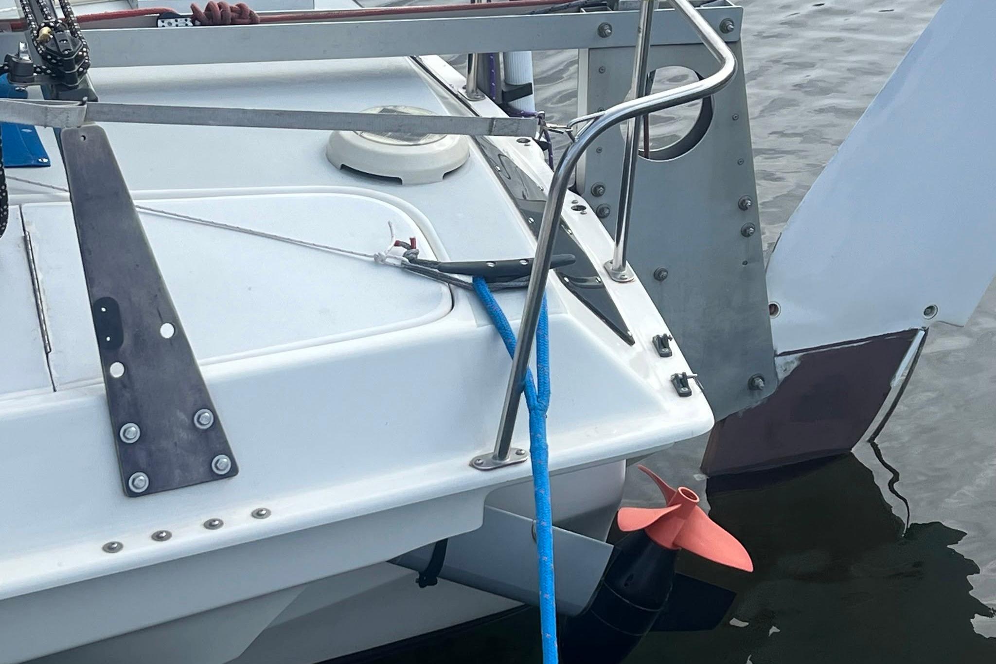 Close-up of a 1993 Corsair F-27 sailboat's stern with blue rope and rudder.