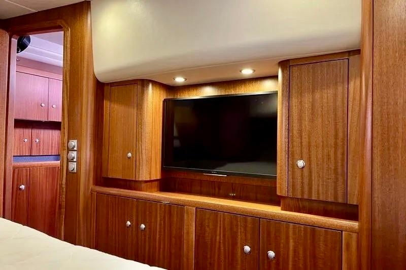 Luxurious wooden interior of 2009 Najad 570 yacht with built-in TV and cabinets.