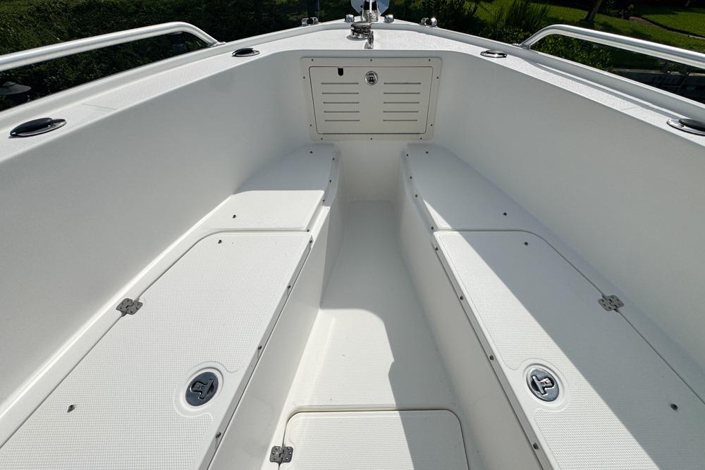 2018 Mako 284 Center Console boat interior with white seating and storage compartments.