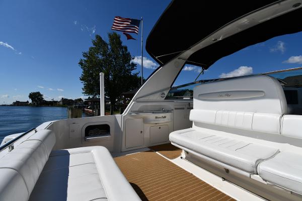 1997 Sea Ray 400 Sundancer yacht with white seating, American flag, and scenic water view.
