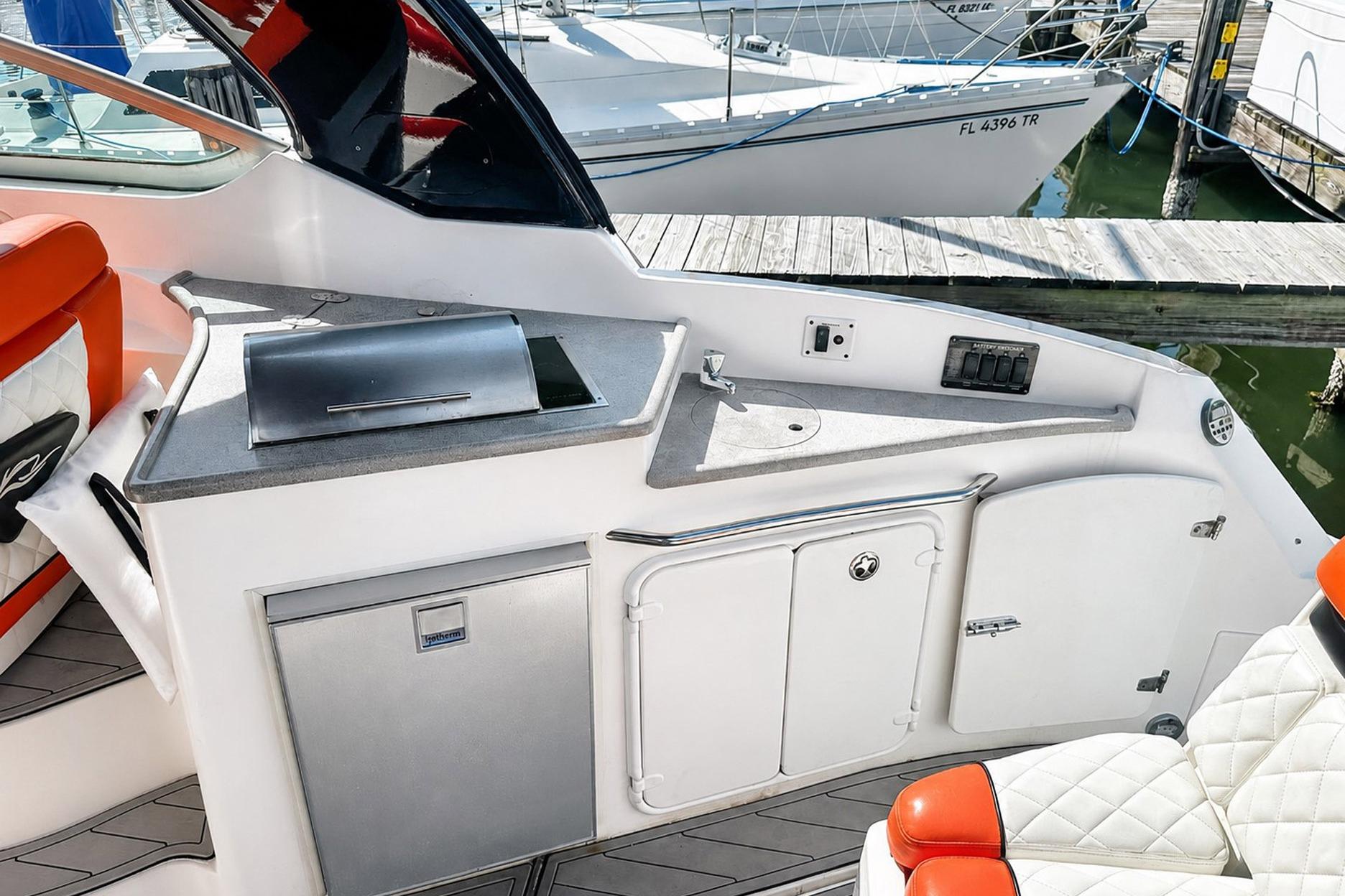 2012 Rinker 310 Express Cruiser LE cockpit with kitchenette and seating area.
