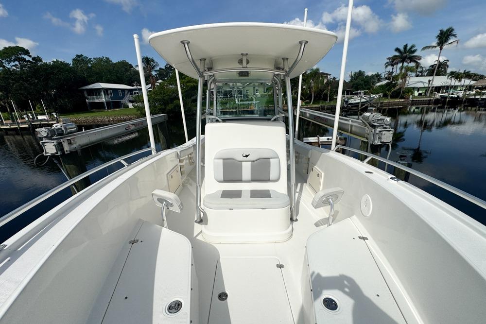 2018 Mako 284 Center Console boat docked, featuring spacious seating and clear skies.