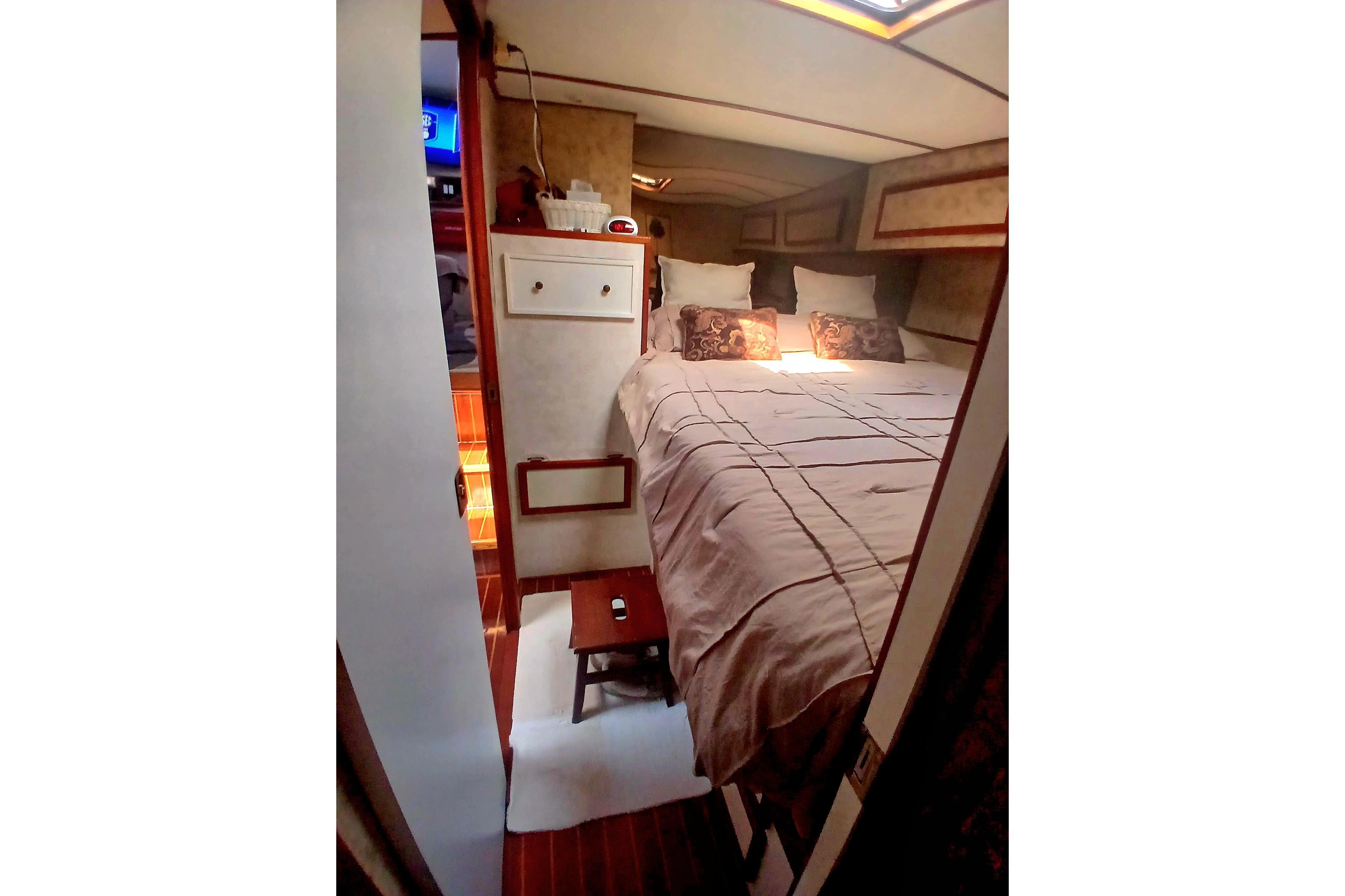 Cozy bedroom interior of 1976 Viking 40 Sedan Diesel yacht with elegant bedding.