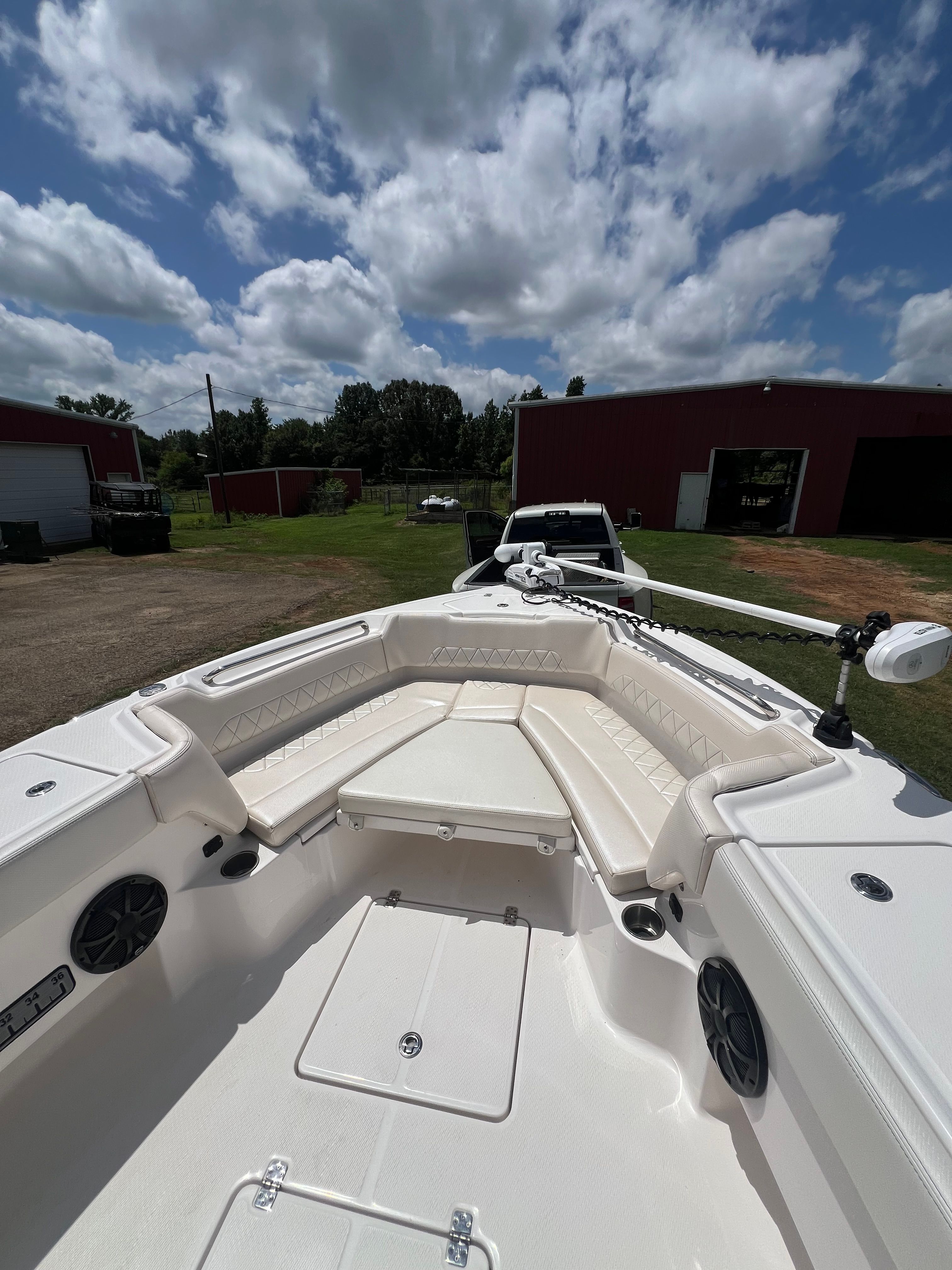 The image shows the deck of a 2023 Blue Wave 2800 Makaira boat with white seating and speakers.