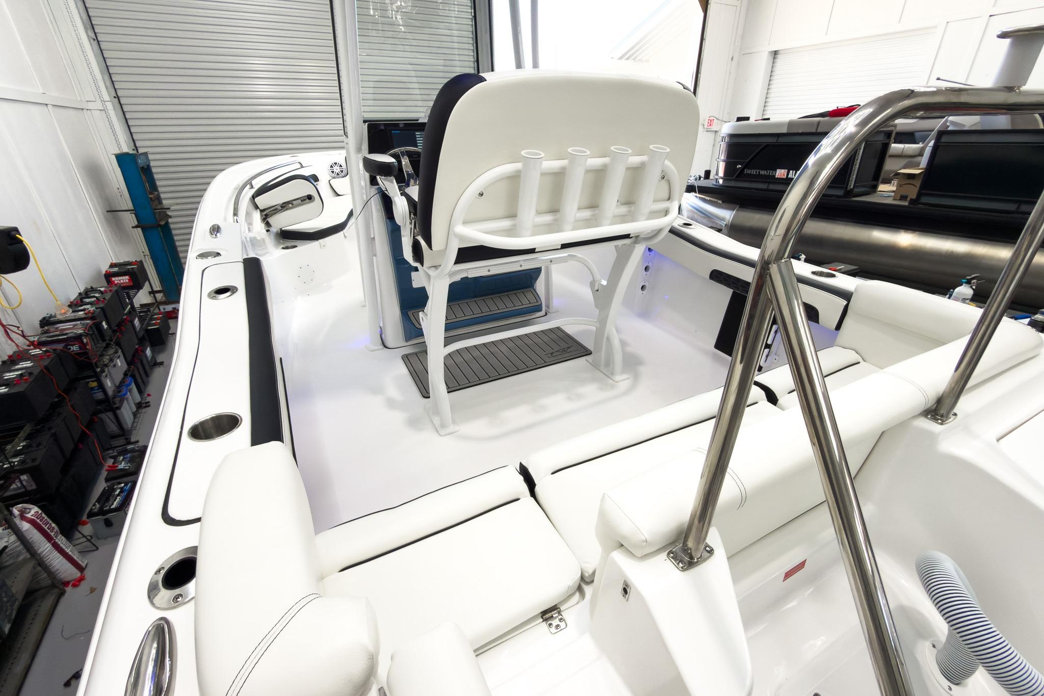 The image shows the interior of a 2026 Tidewater 220 LXF boat with white seating and stainless steel railings.