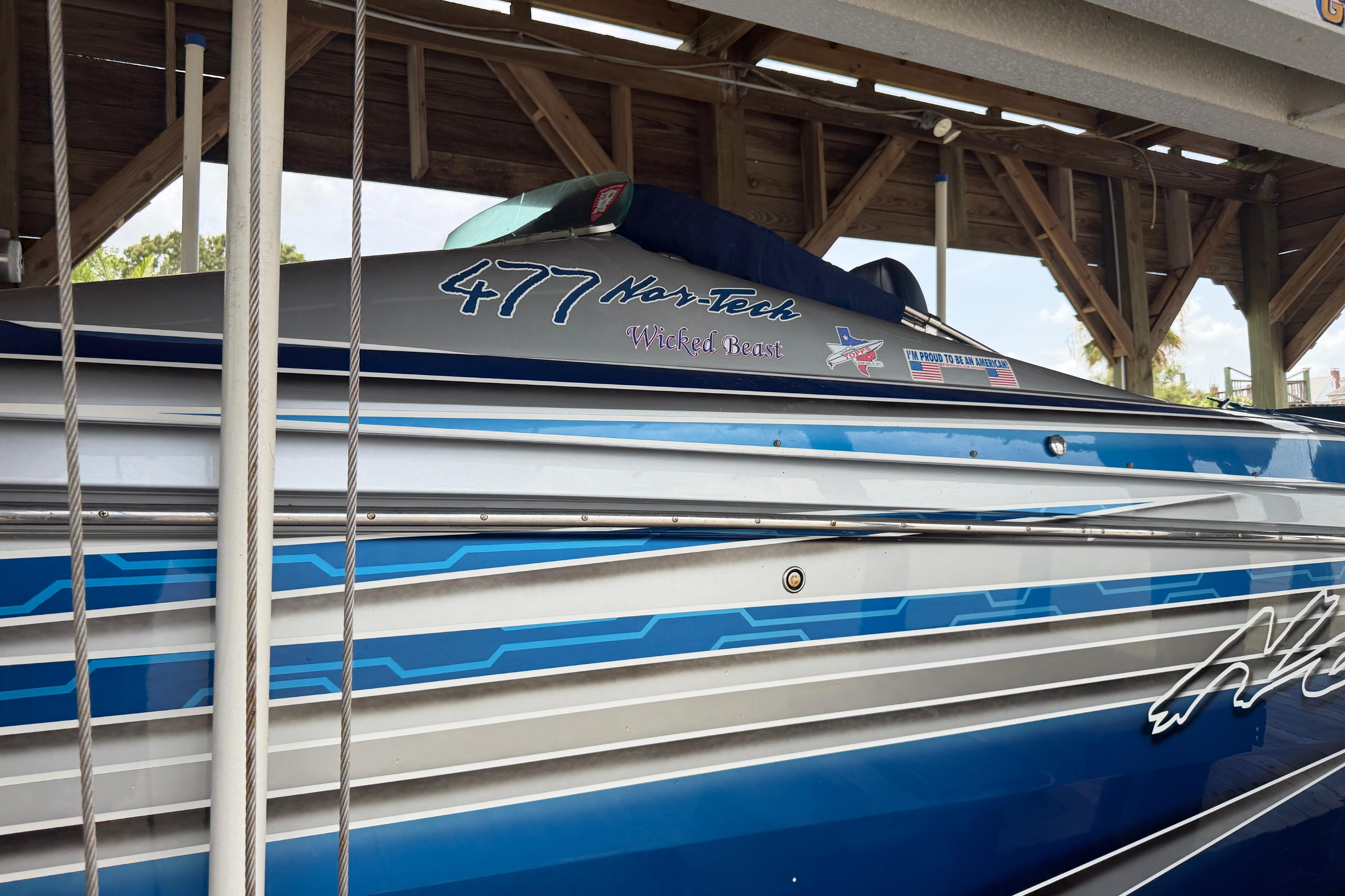 2013 Nor-Tech 477 SPX Vee Bottom boat with blue and silver detailing in a dock.