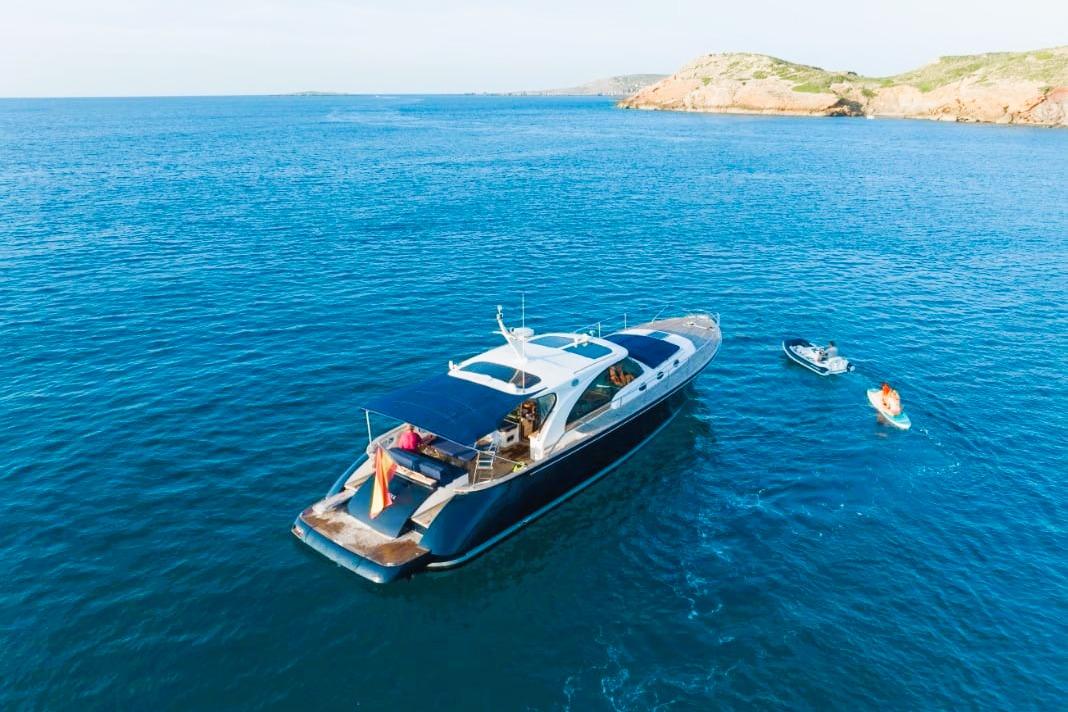 Luxurious 2009 Franchini Emozione yacht on serene blue waters near rocky coastline.