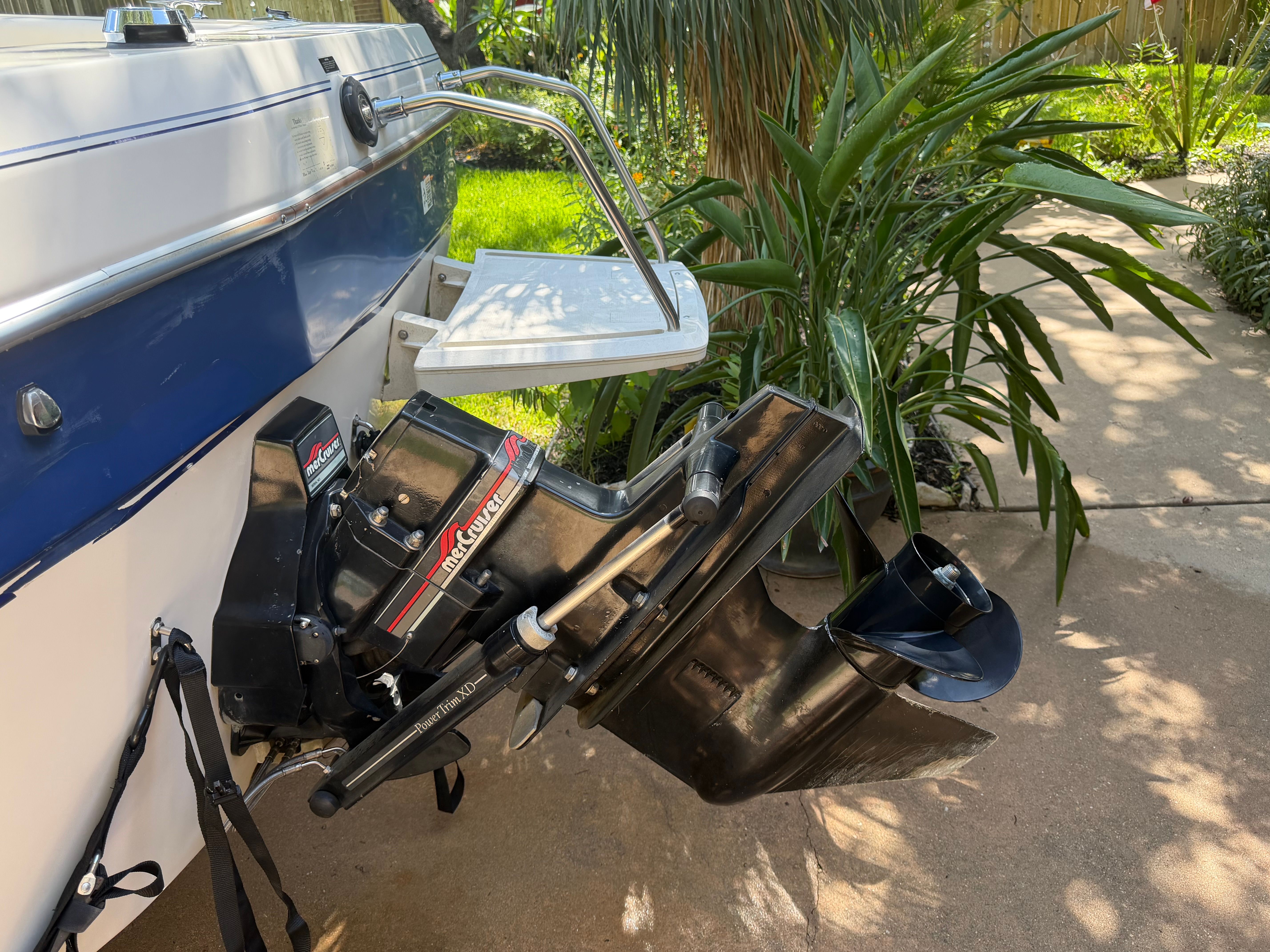 A 1994 Bayliner CAPRI with an outboard motor and swim platform in a garden setting.