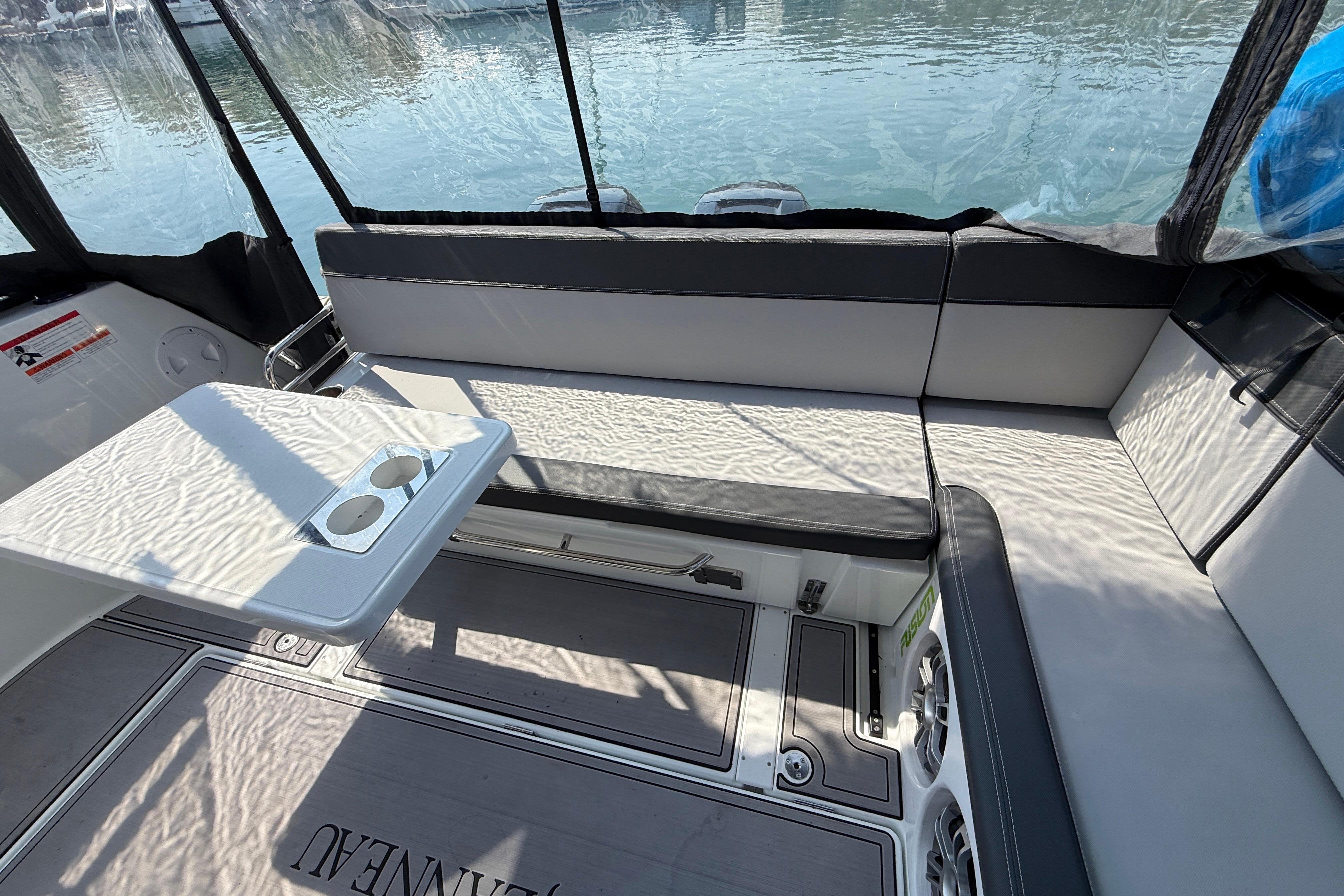 Interior seating area of 2022 Jeanneau NC 1095 Fly boat with table and cup holders.
