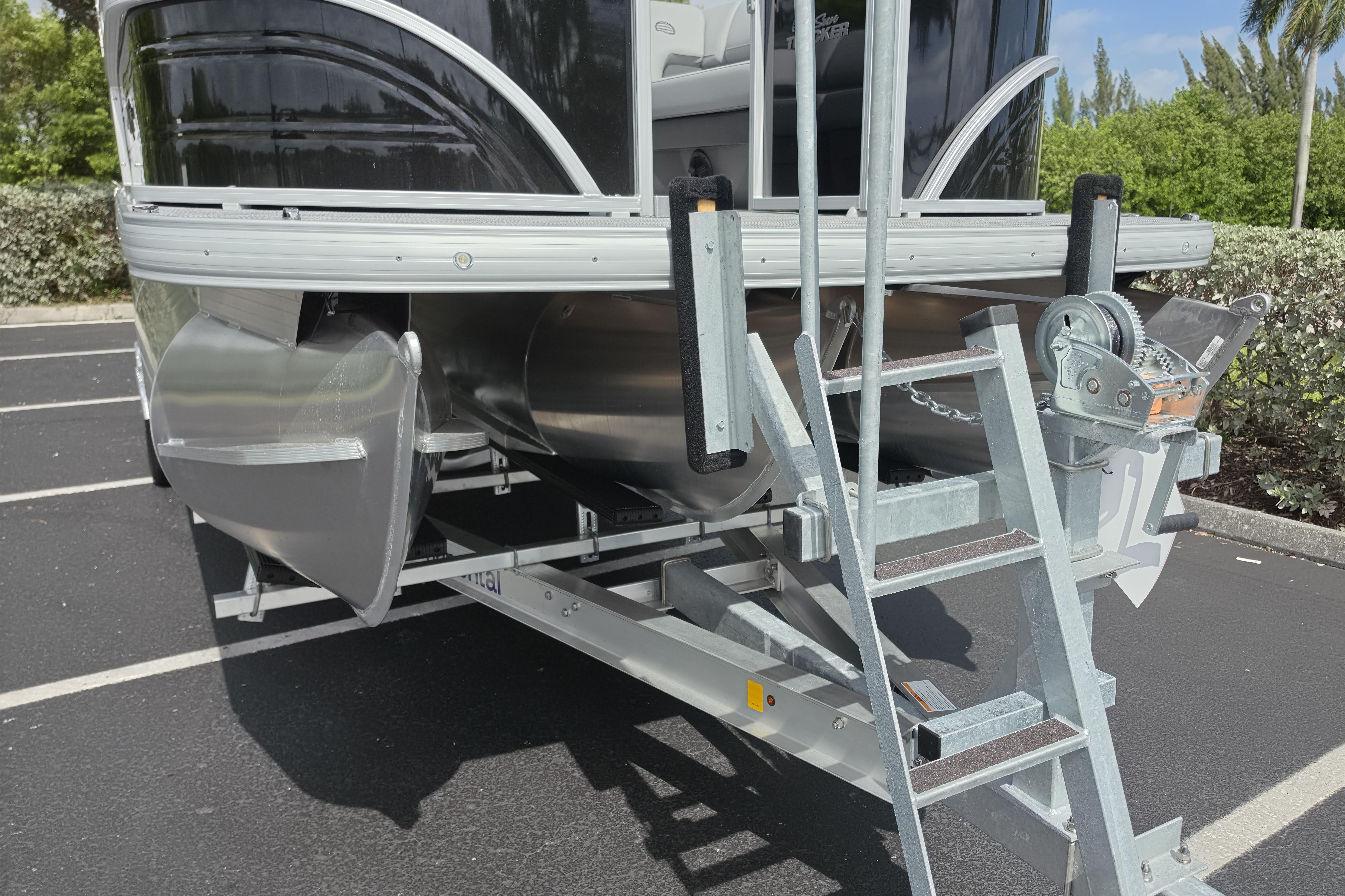 2026 Sun Tracker Party Barge 24 XP3 on trailer in parking lot.