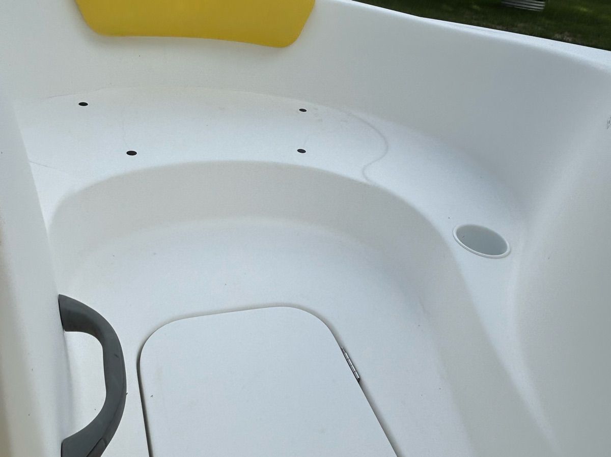 Interior view of a 2004 Sea-Doo Sportster LE DI with white seating and a yellow accent.