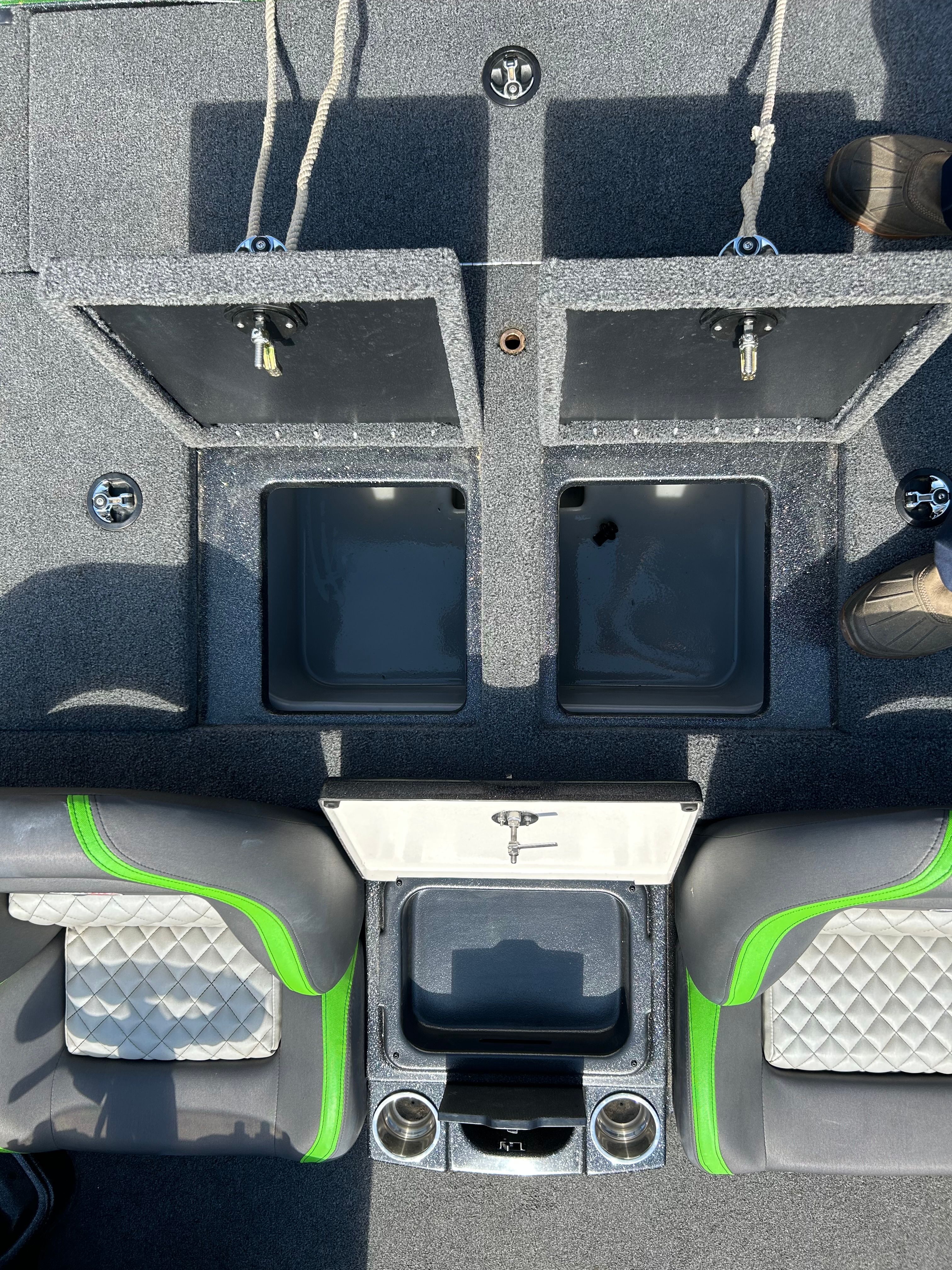 Interior of a Trident 189 TRX boat with gray carpeting and green accents.
