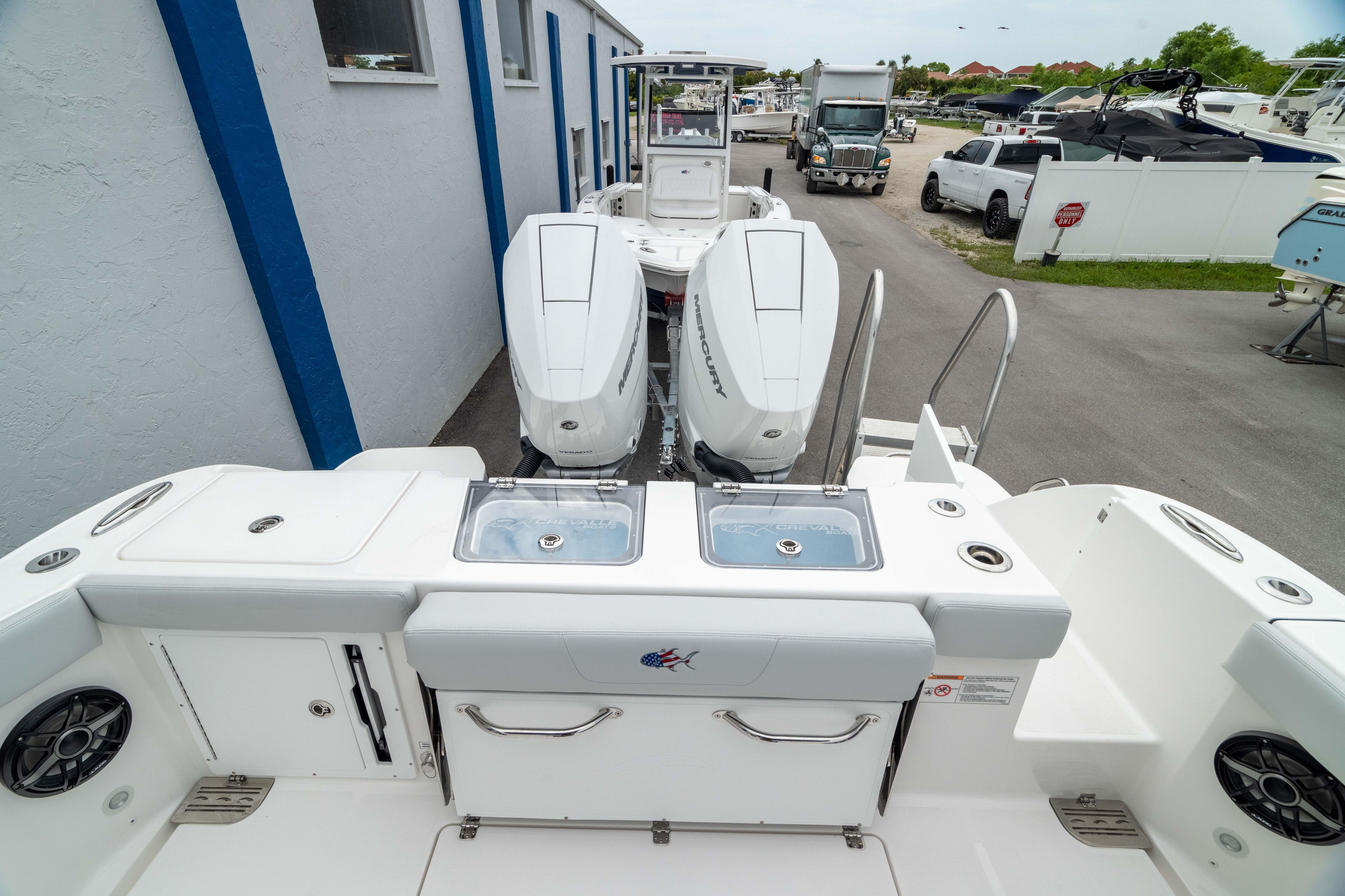 2026 Crevalle 33 CSF boat with dual outboard engines, docked near a building.