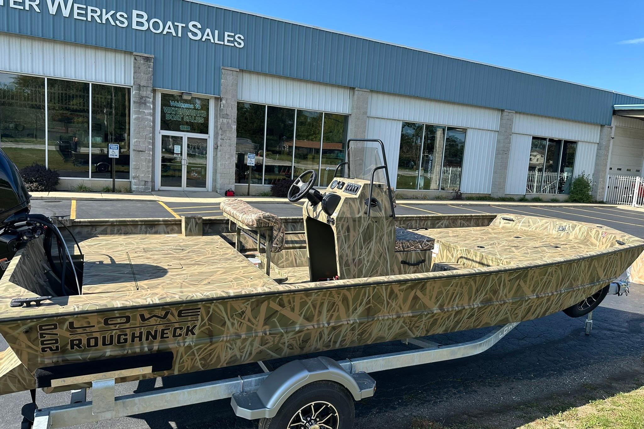 2026 Lowe Roughneck 2070CC boat on trailer outside dealership.
