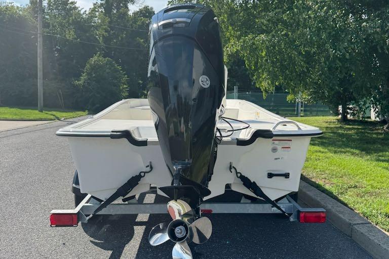 2026 Mako Pro Skiff 17 CC on trailer, rear view with outboard motor.
