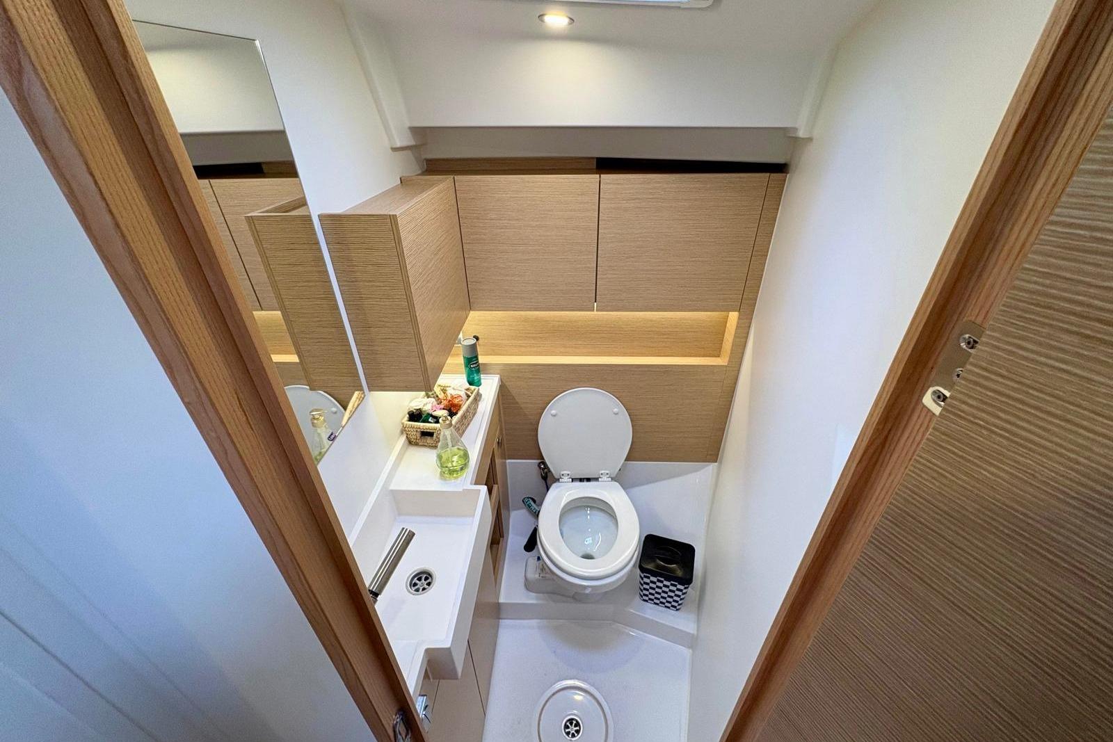 Bathroom interior of 2024 Hanse 410 yacht, featuring modern fixtures and wooden cabinetry.