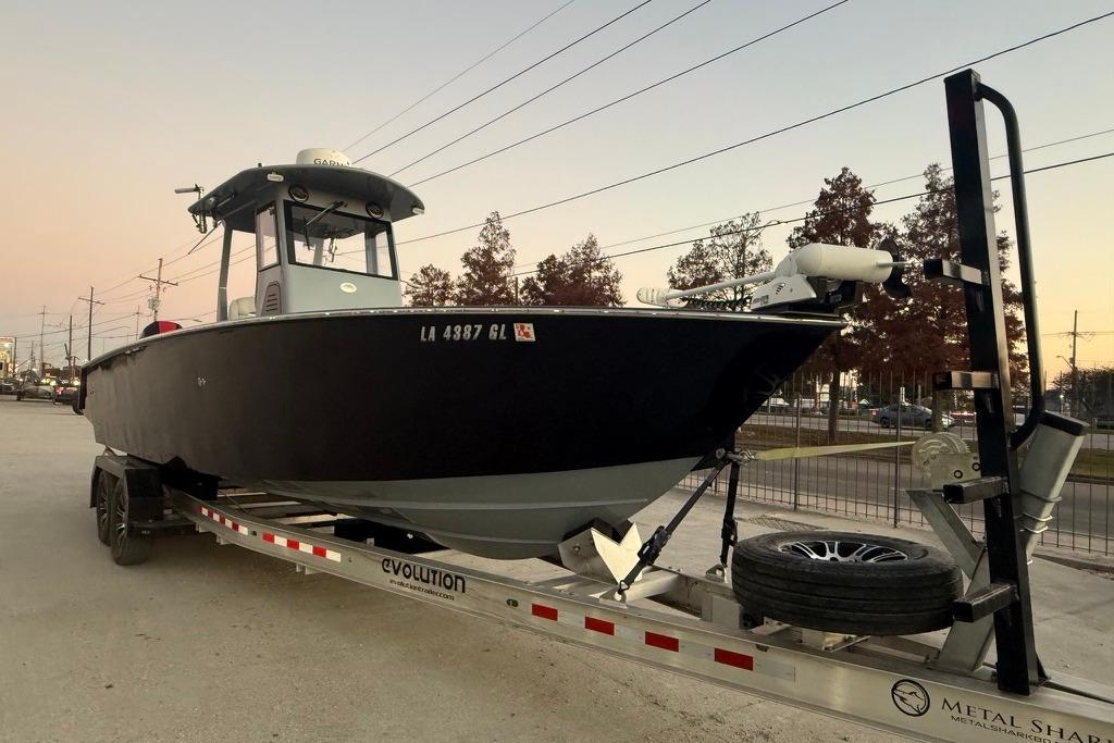 2019 Metal Shark 28 CC boat on trailer at sunset, parked on roadside.