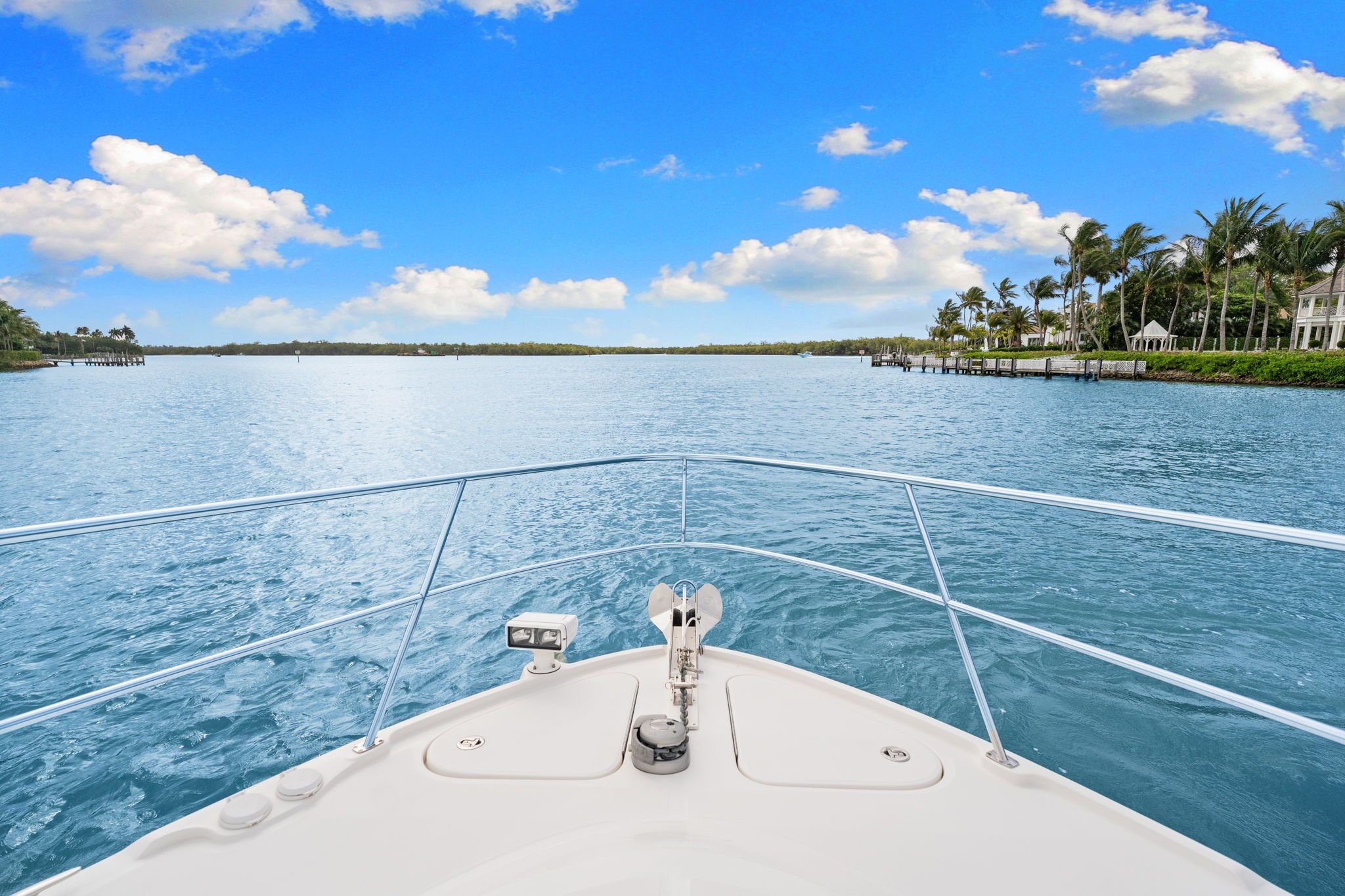 View from the bow of a Sea Ray Sundancer 510 over calm water and a clear sky.