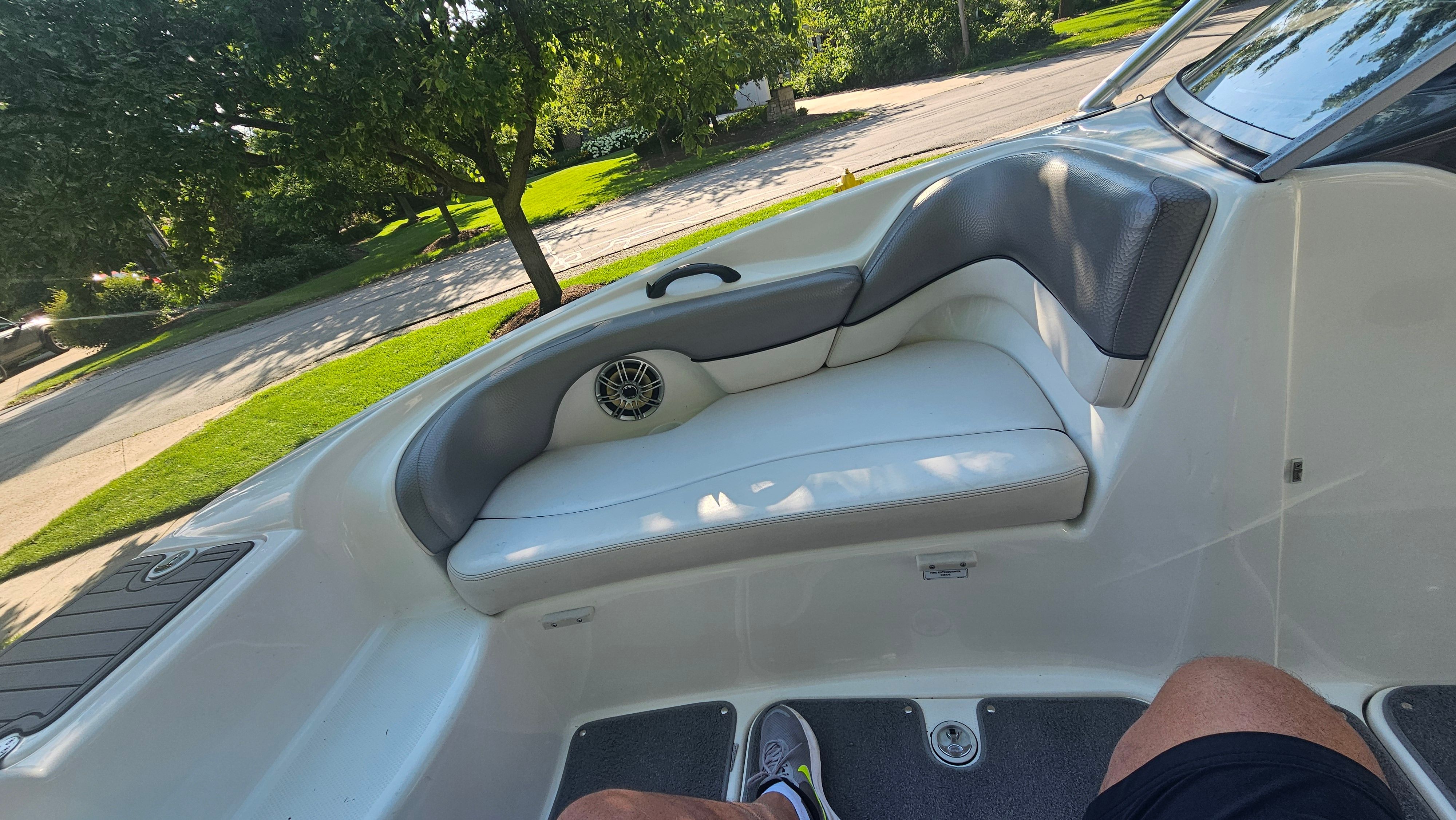 The image shows the seating area of a 2010 Yamaha AR210 boat with gray and white upholstery.