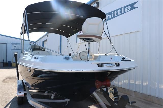 2022 Stingray 212 SC with black hull and bimini top, on a trailer.