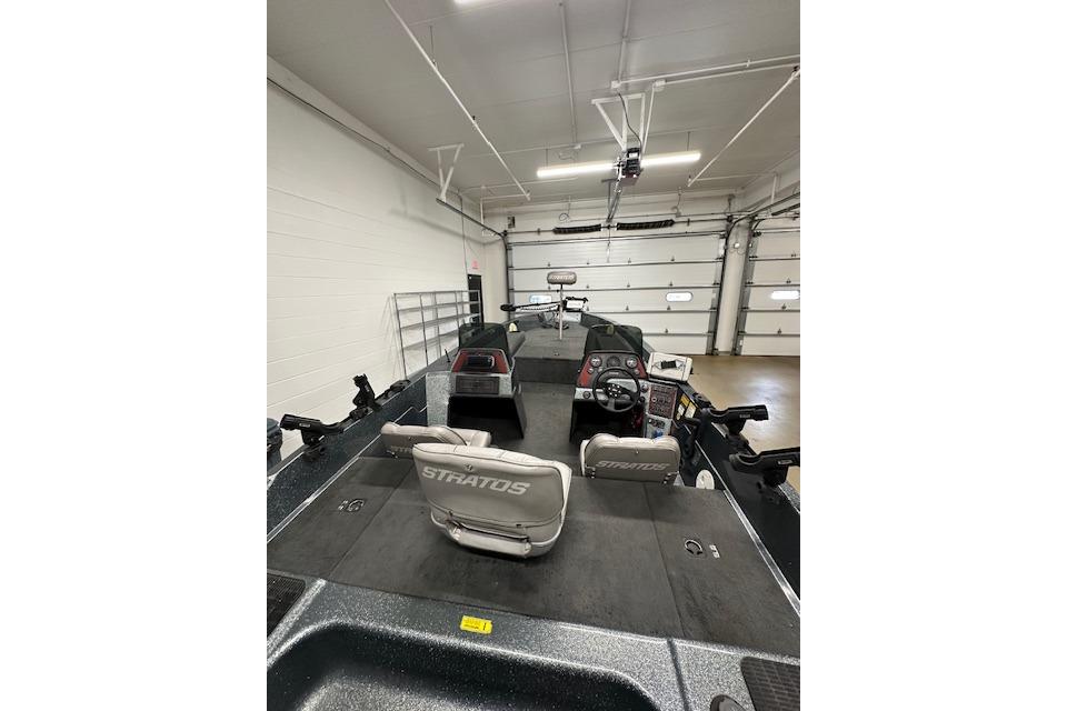 1999 Stratos 219 CF boat interior with steering console and seating in a garage.