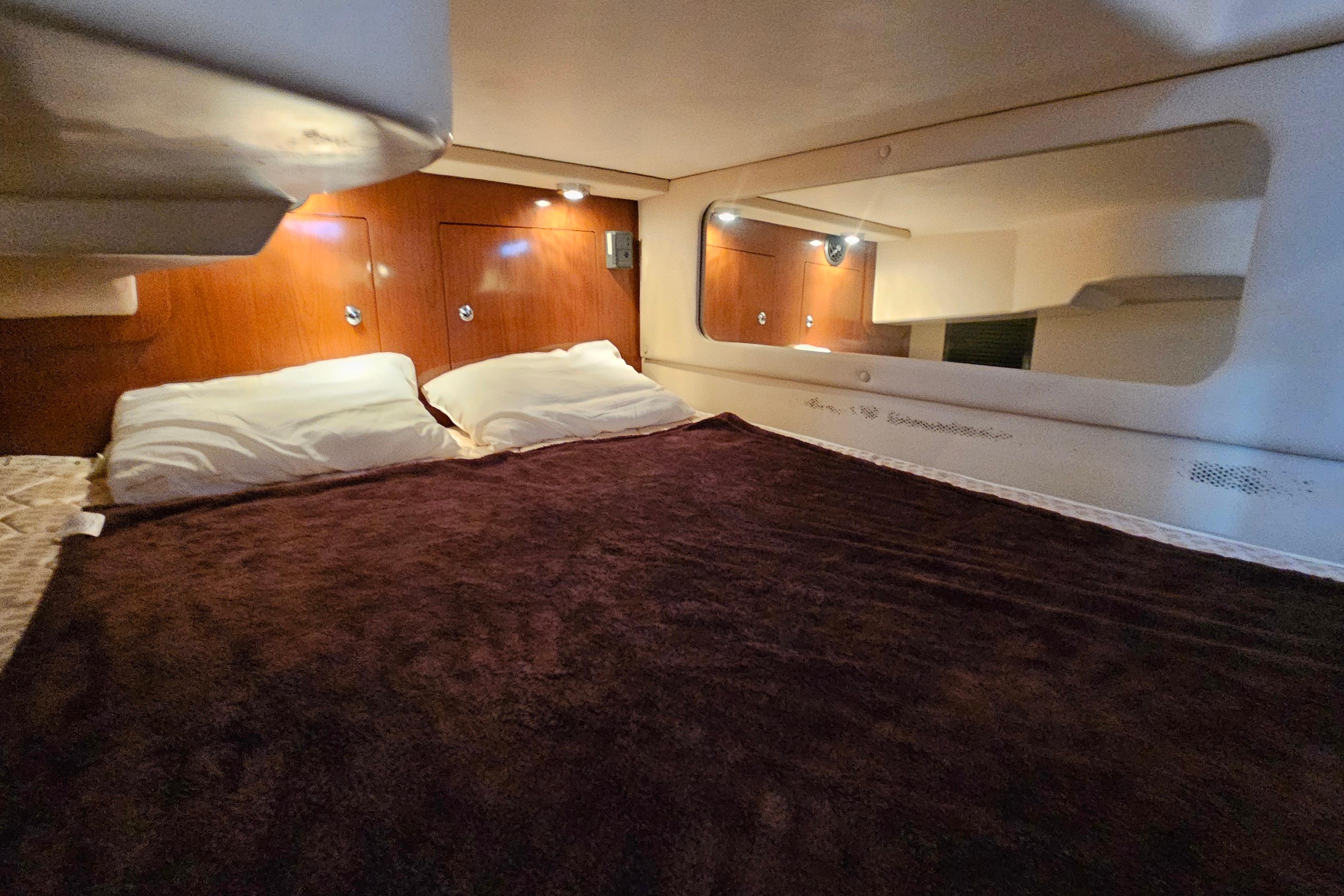 Cozy cabin interior of 2005 Regal 3060 Window Express with plush bedding and warm lighting.