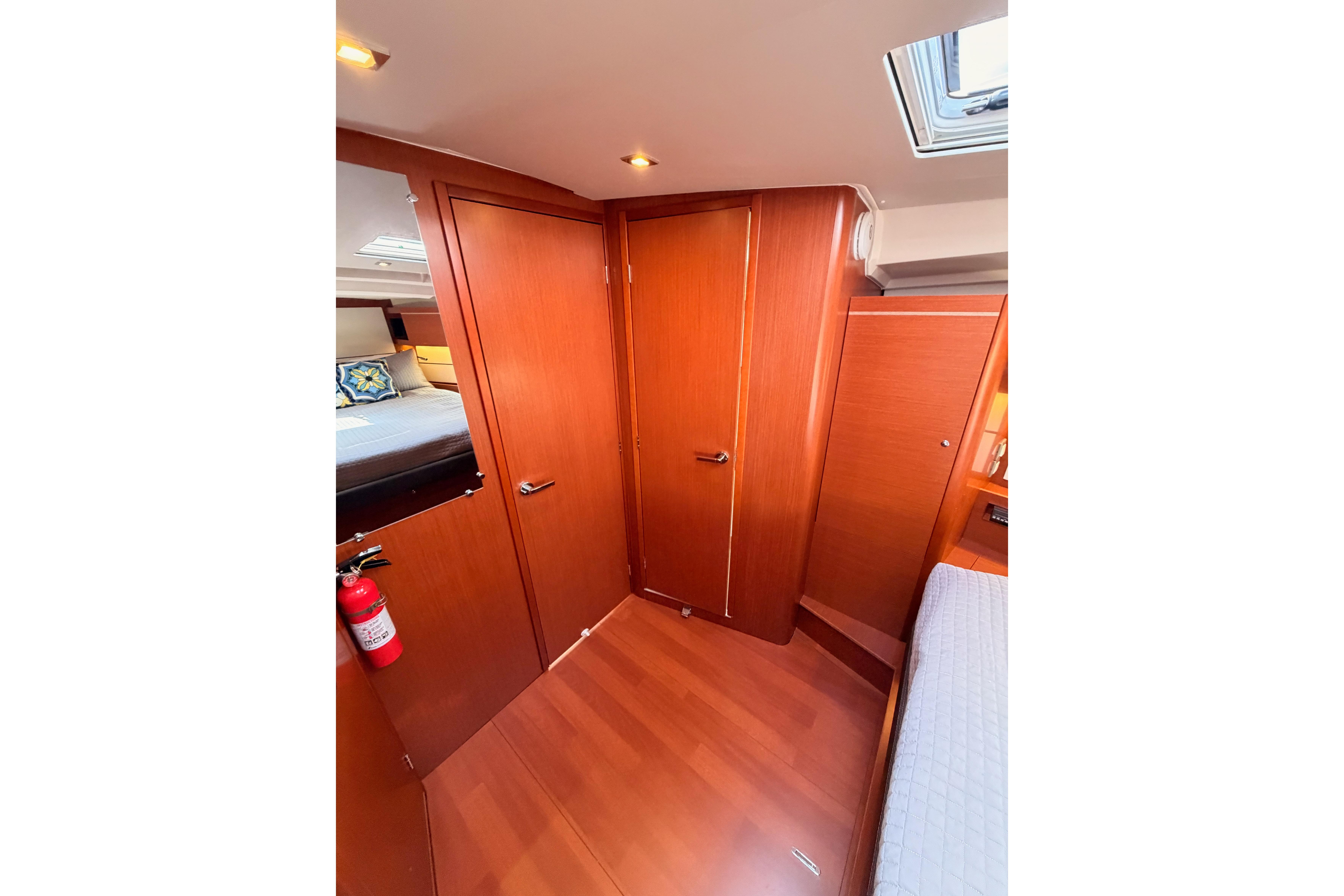 Interior of 2020 Beneteau Oceanis 46.1 yacht cabin with wooden finish and cozy bedding.
