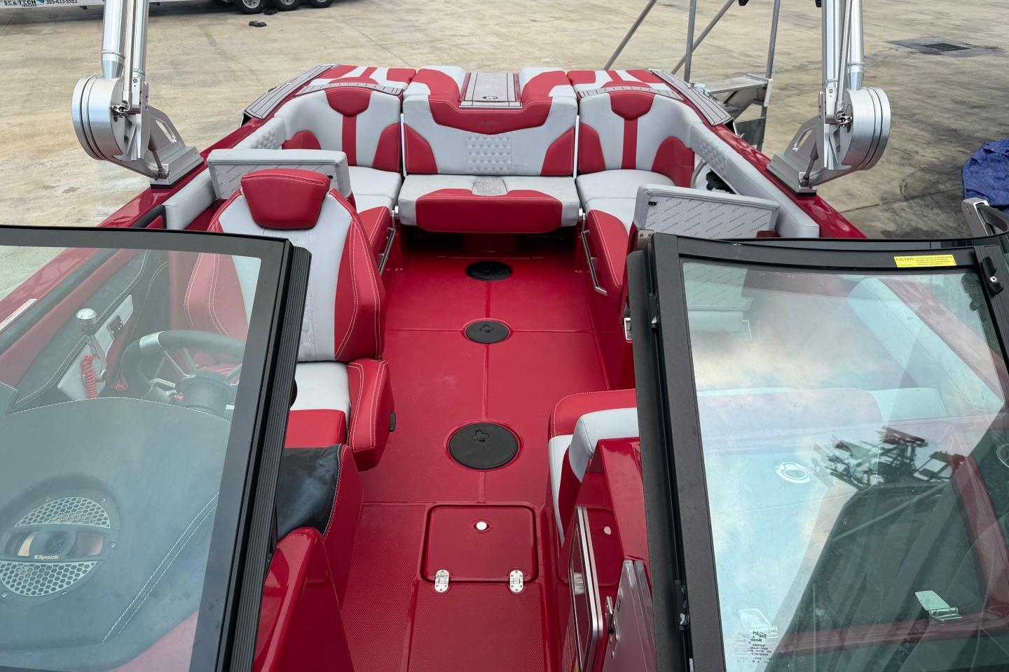 2023 MasterCraft X24 boat interior with red and white seating, open deck view.