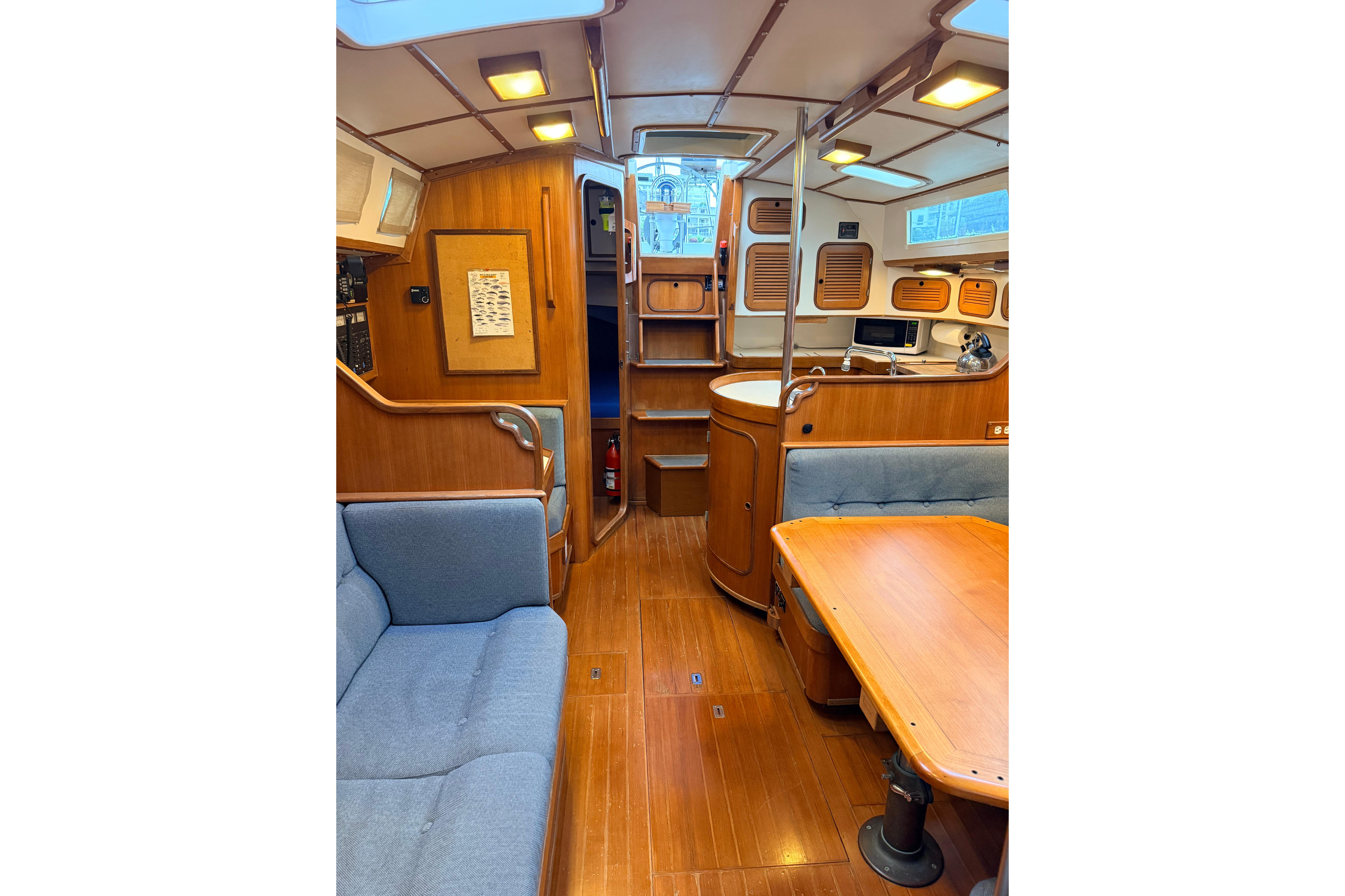 Interior of 1987 Norseman 400 sailboat with wooden furnishings and cozy seating area.