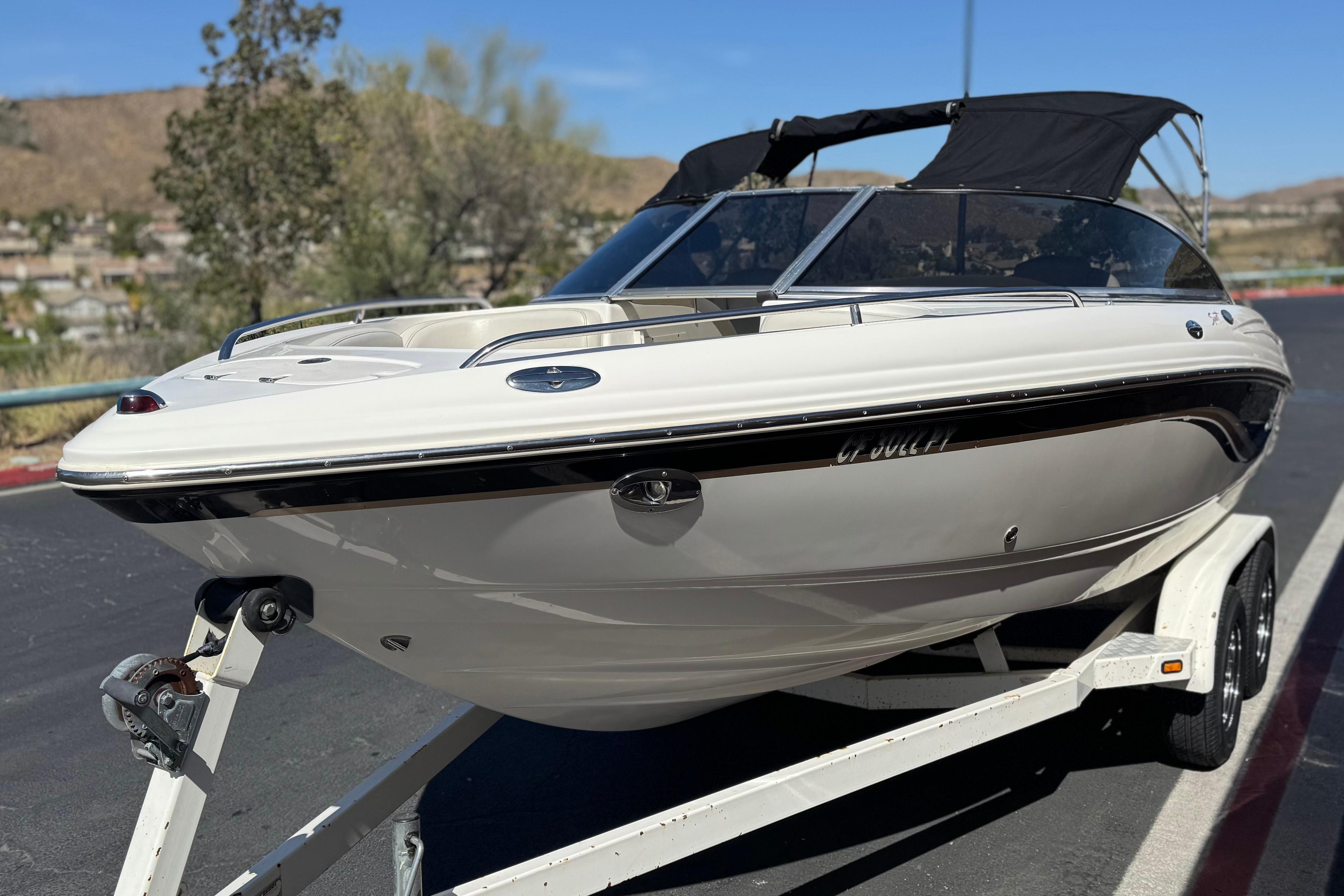 2002 Chaparral 186 SSi boat on trailer, parked outdoors, with black canopy.