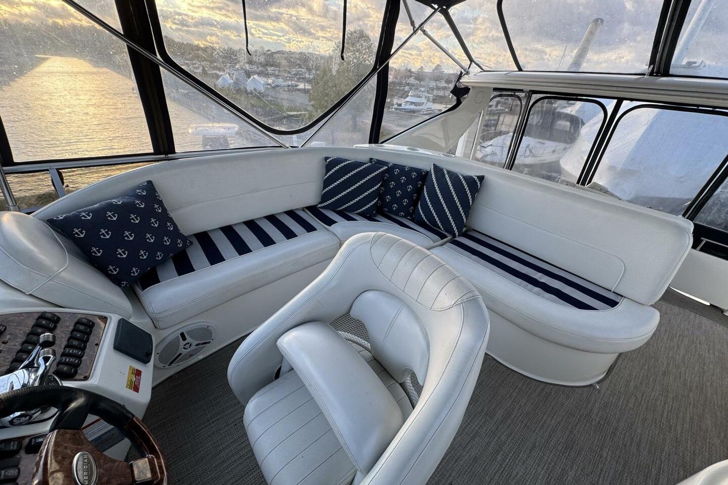 Luxurious interior of 2008 Meridian 459 Motoryacht with plush seating and nautical-themed cushions.