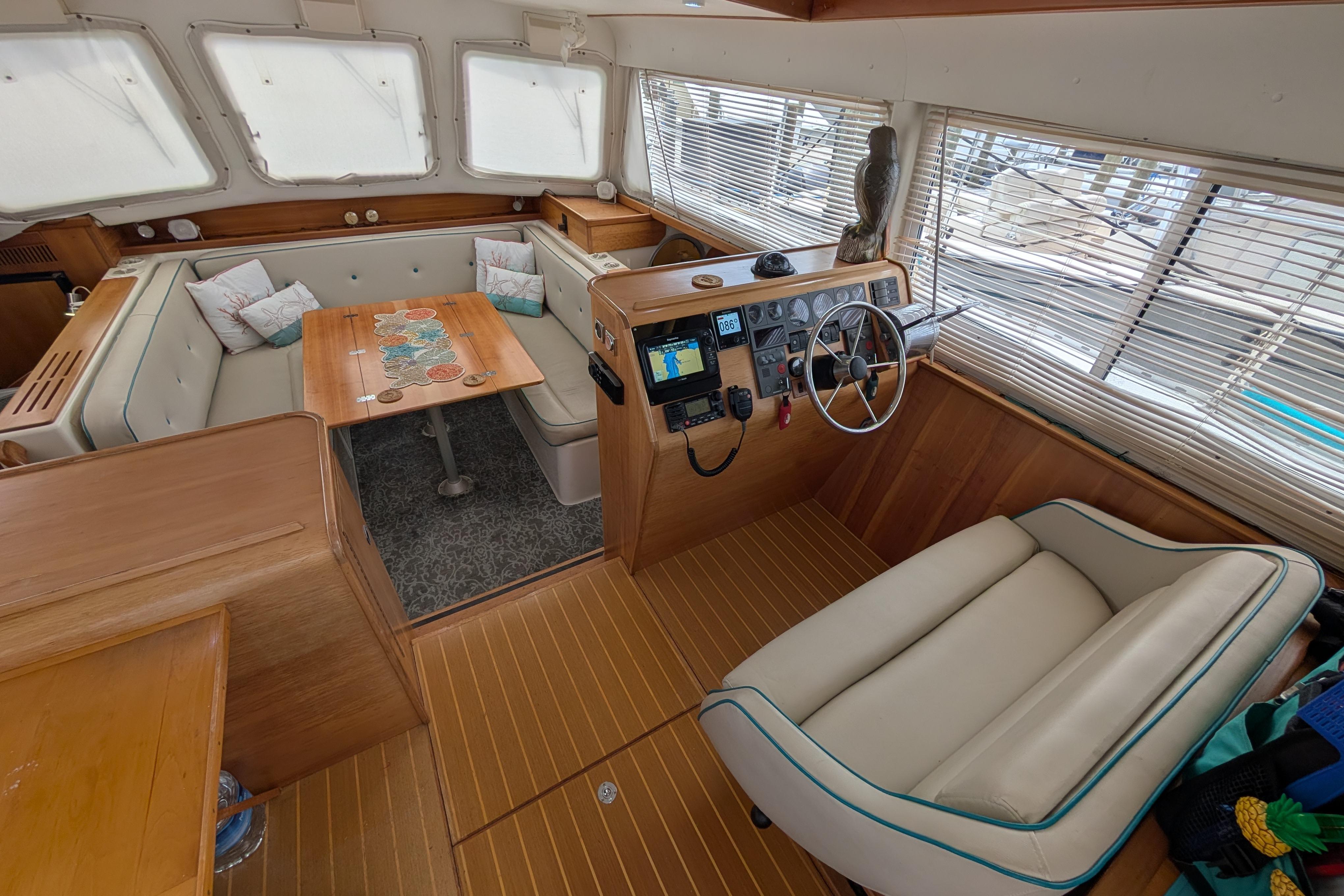 Interior of 2004 PDQ 34 Powercat with helm, seating, and dining area.