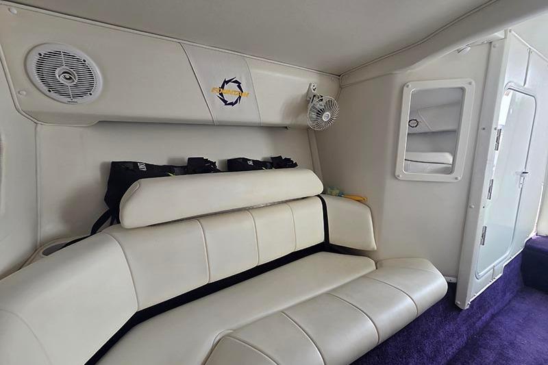 Interior of a 2004 Fountain 38 Lightning boat with white seating and purple carpet.
