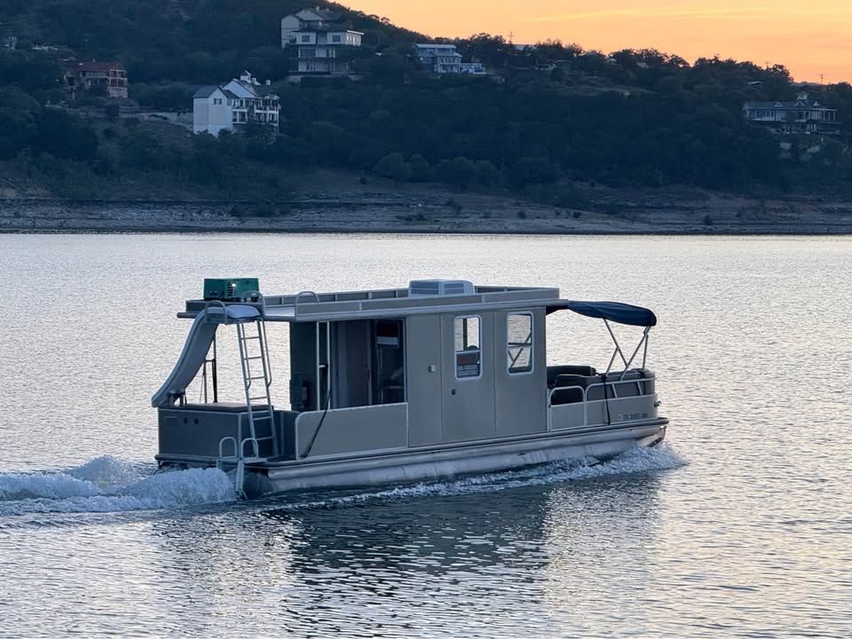 2008 Sun Tracker Party Cruiser on a calm lake at sunset.