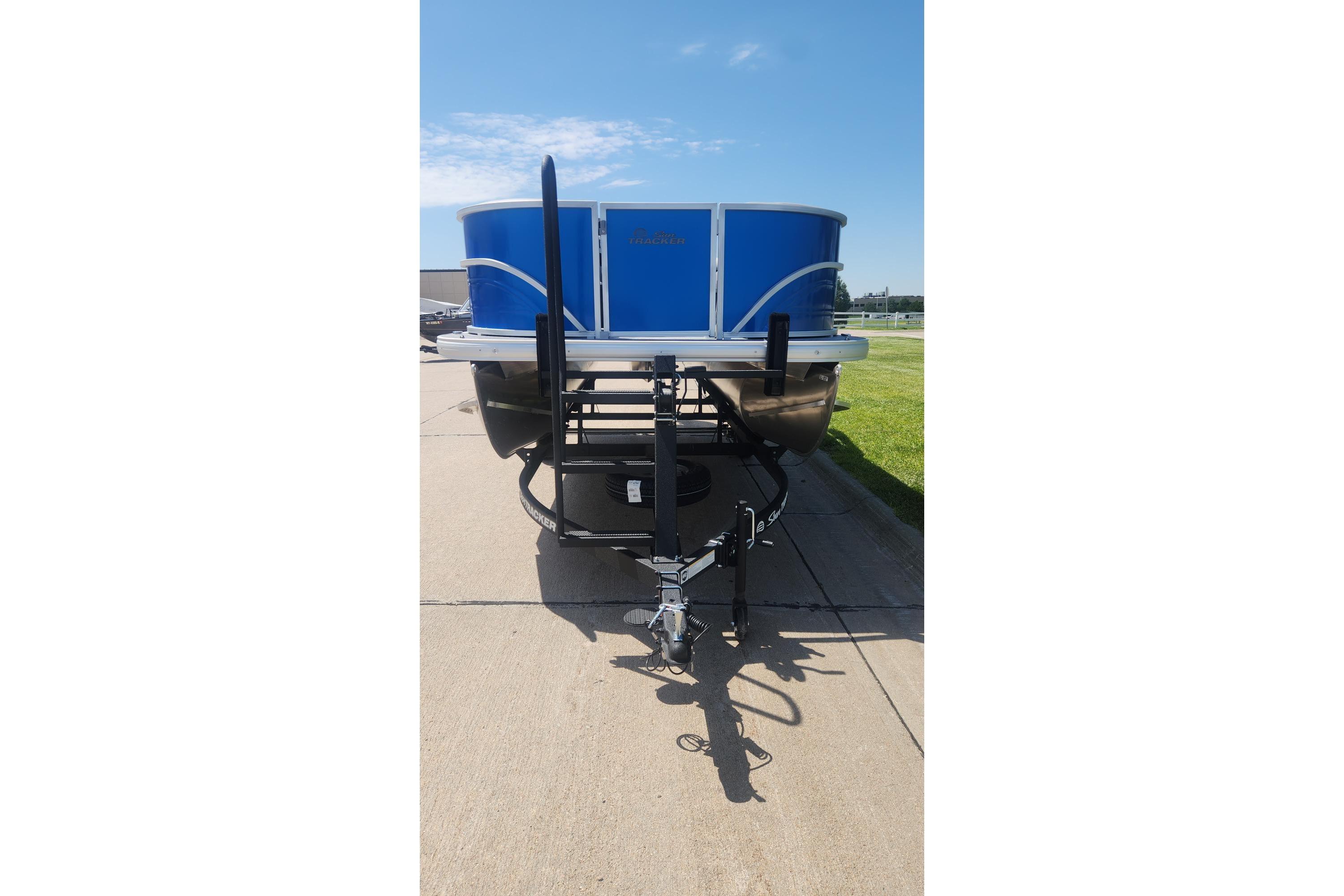 2026 Sun Tracker Party Barge 16 DLX pontoon boat on trailer, parked on pavement.