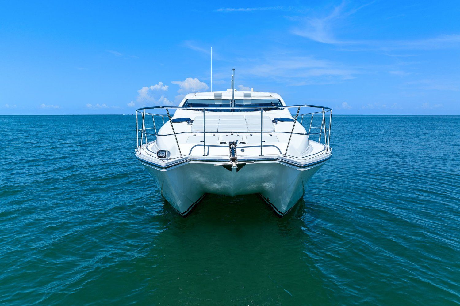 Catamaran on calm sea under blue sky.