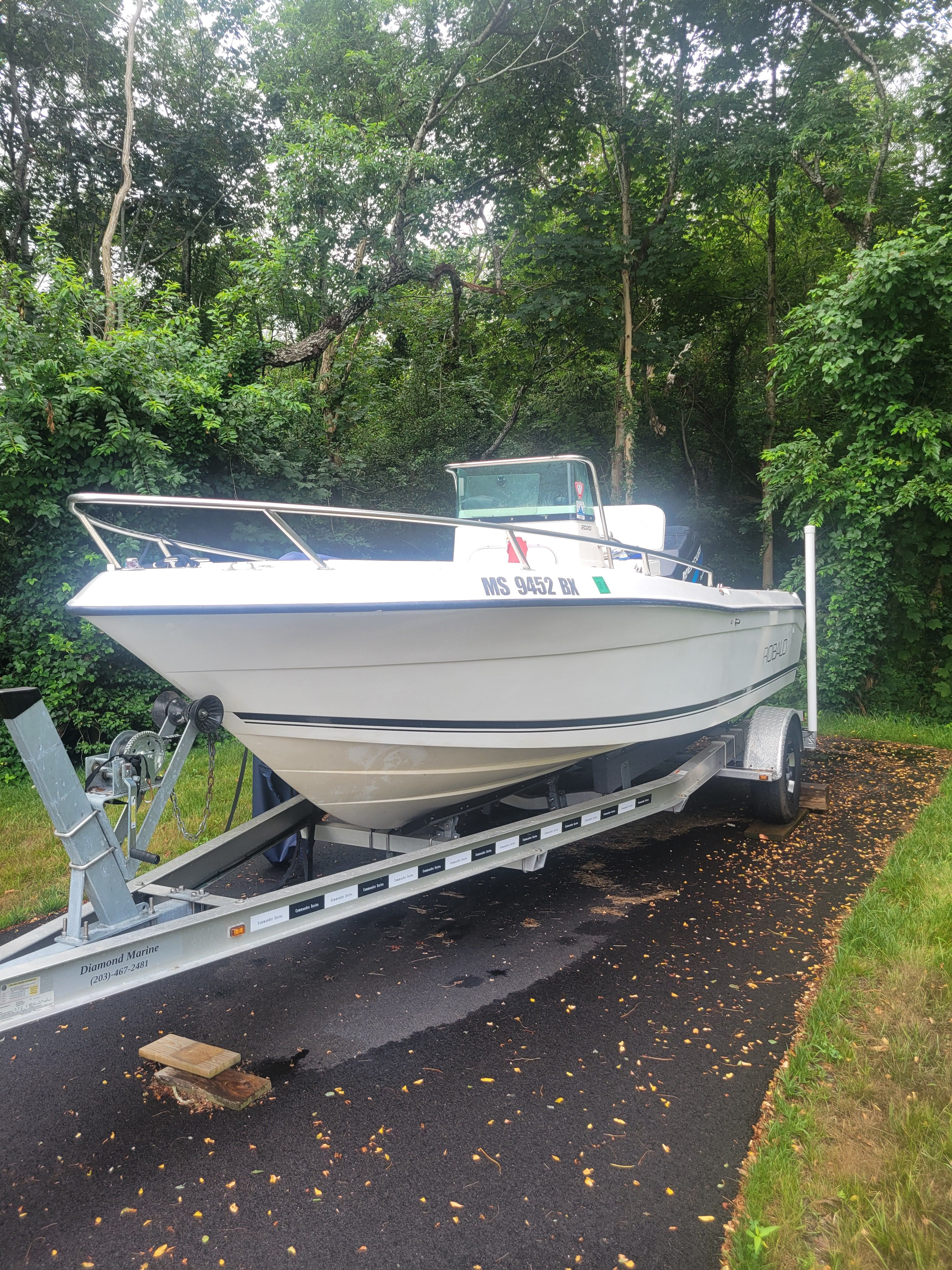 Robalo 2020 Center Console boat on trailer, surrounded by lush greenery.