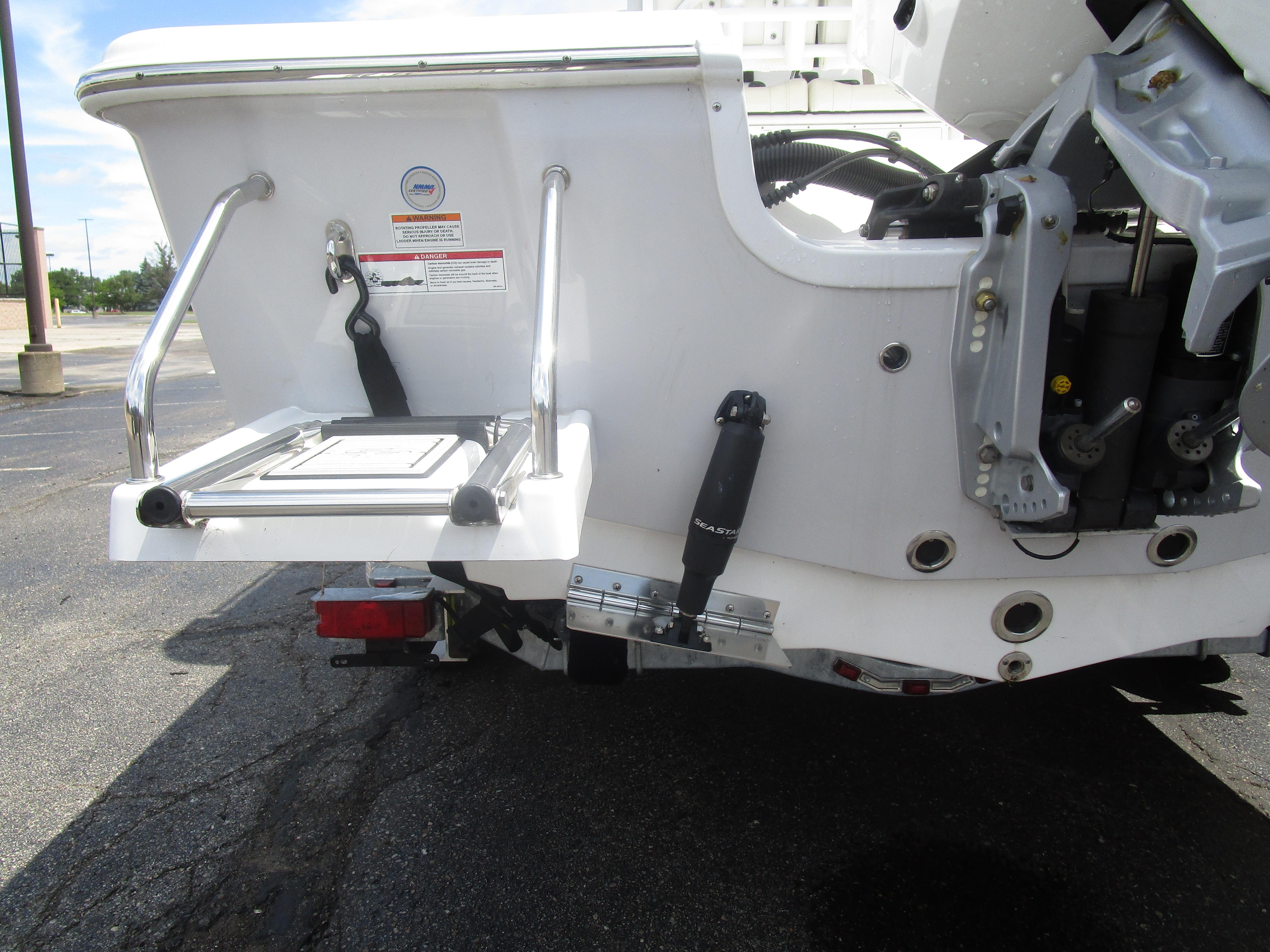 2025 Sea Pro 230 DLX BAY boat stern with swim platform and hydraulic components.