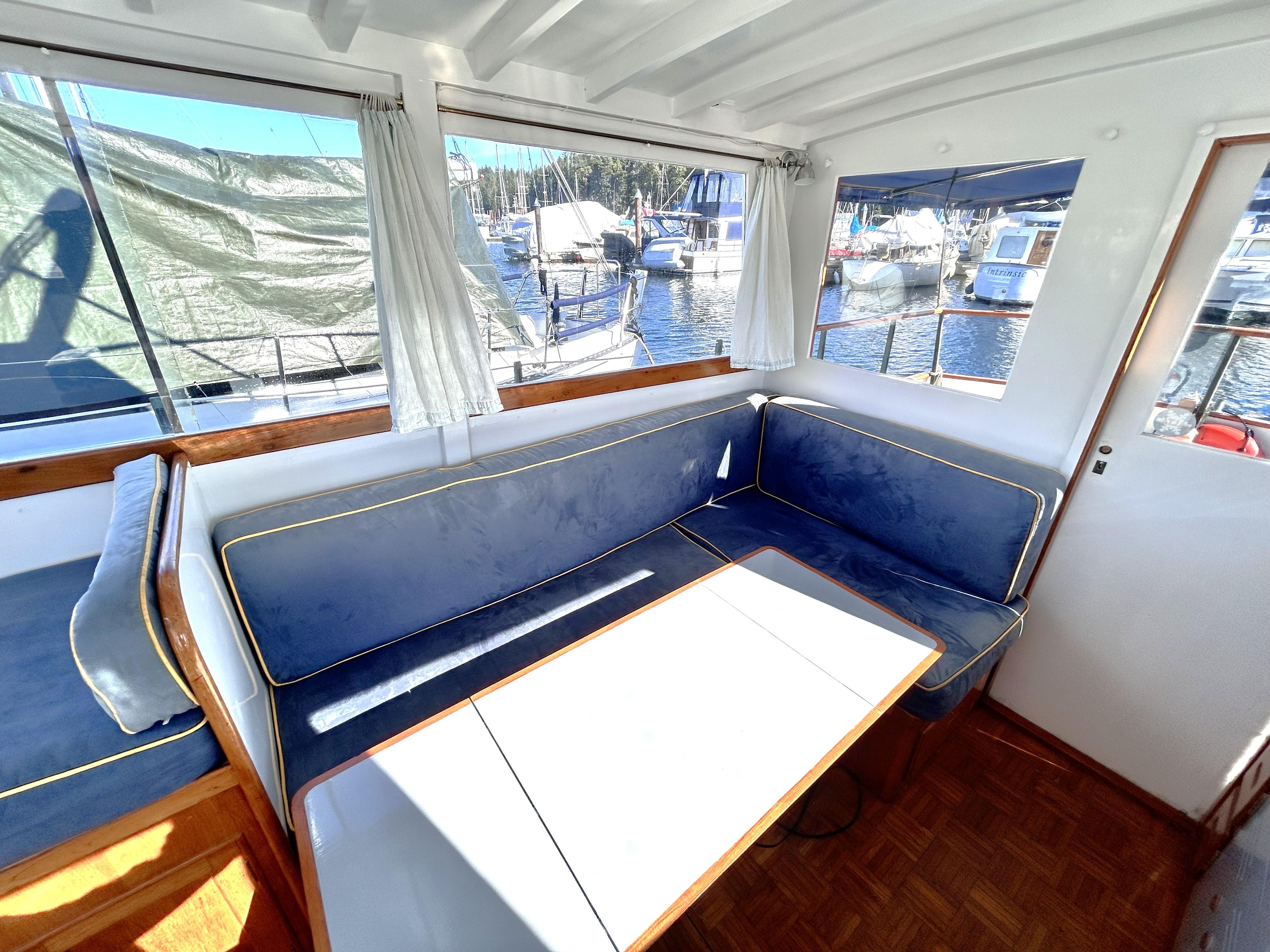 Interior of 1966 Grand Banks 32 Sedan with blue seating and marina view.