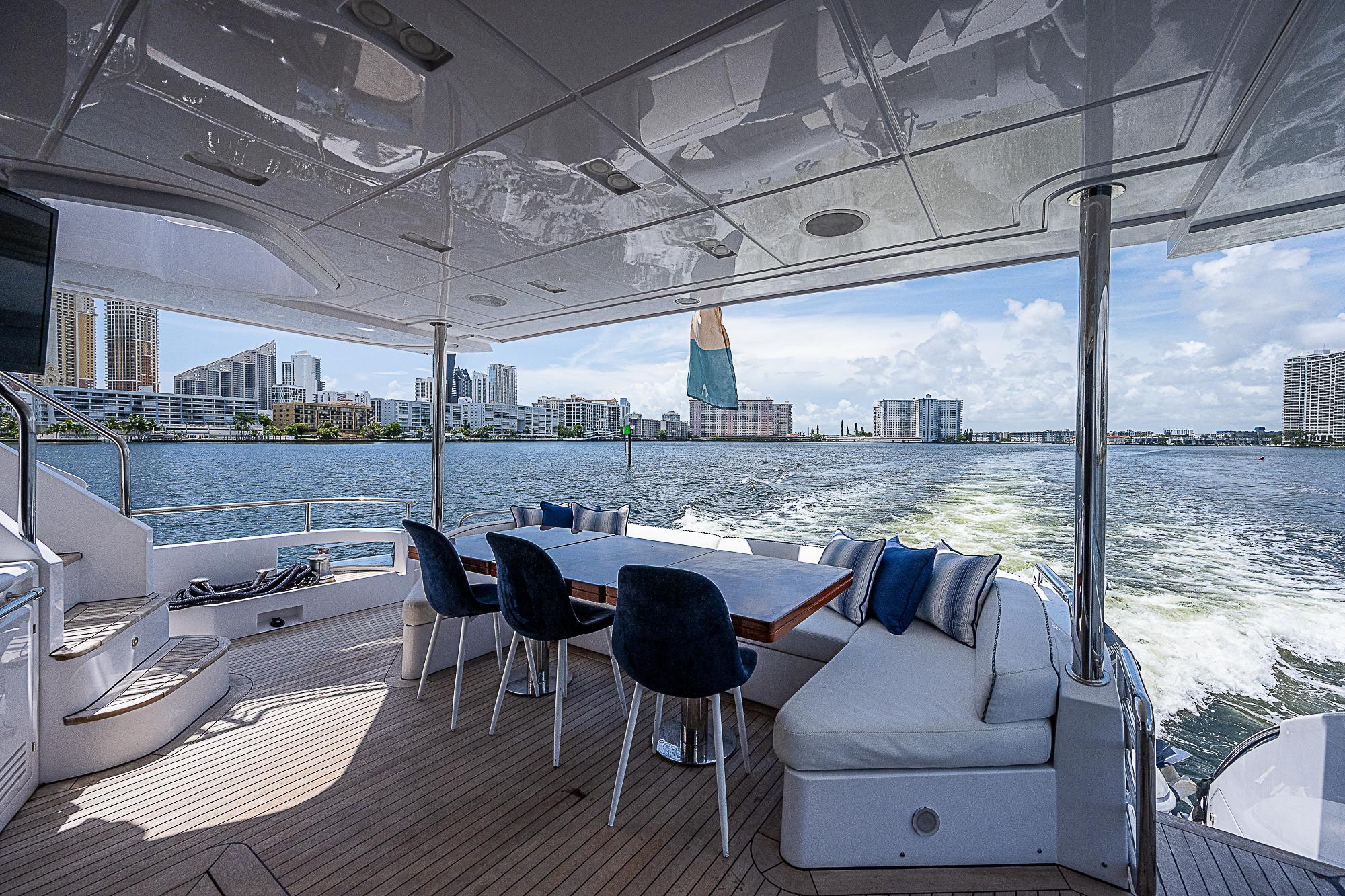Luxurious 2011 Azimut 82 yacht deck with seating, city skyline view.