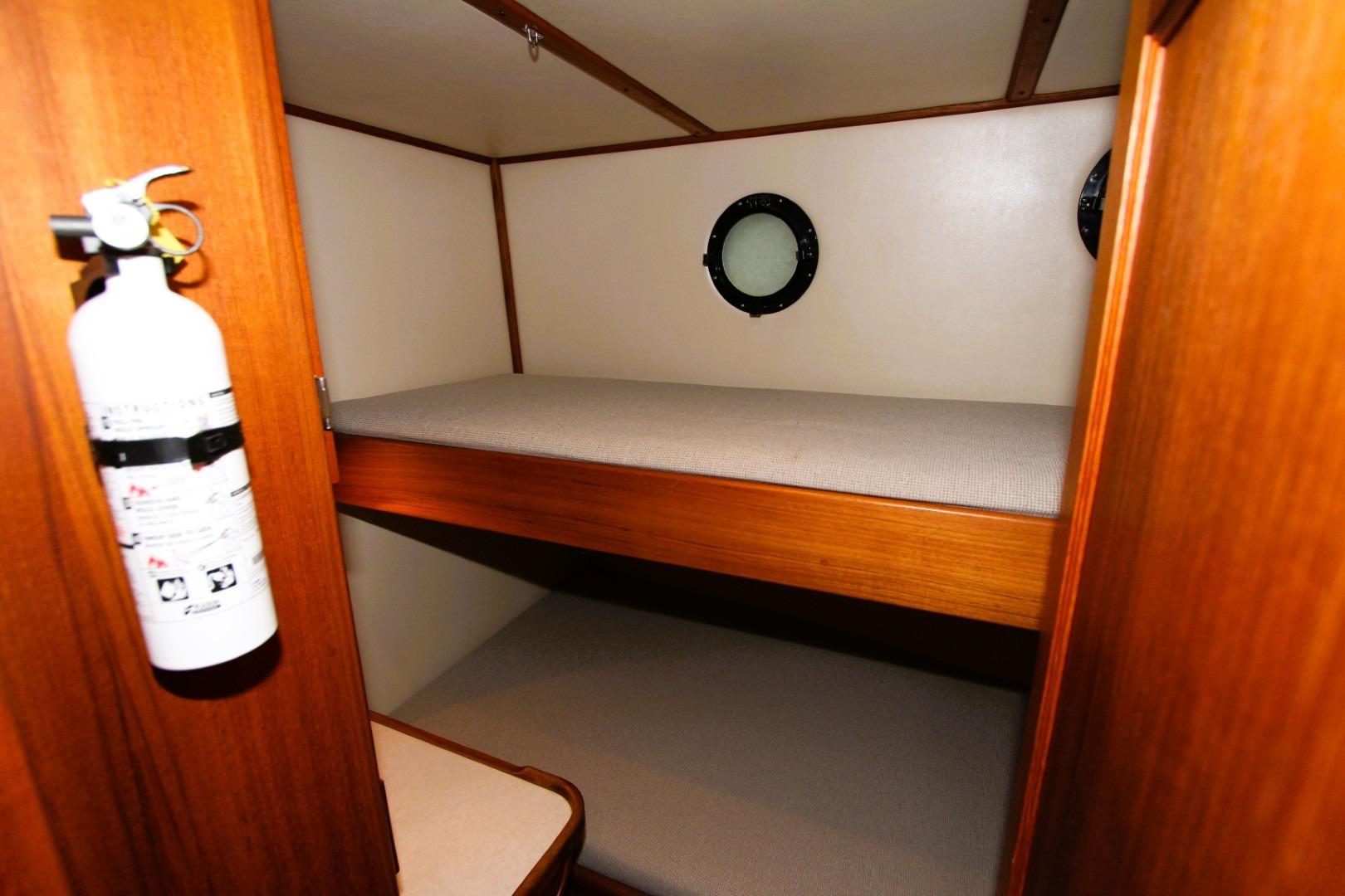 Interior of 2002 Nordic Tug 37 with bunk beds and a fire extinguisher.