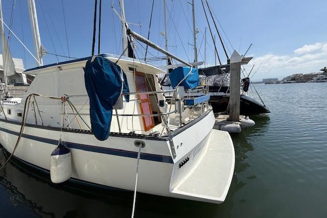 1982 Lancer 45 Motorsailer docked at marina, clear sky, calm water.